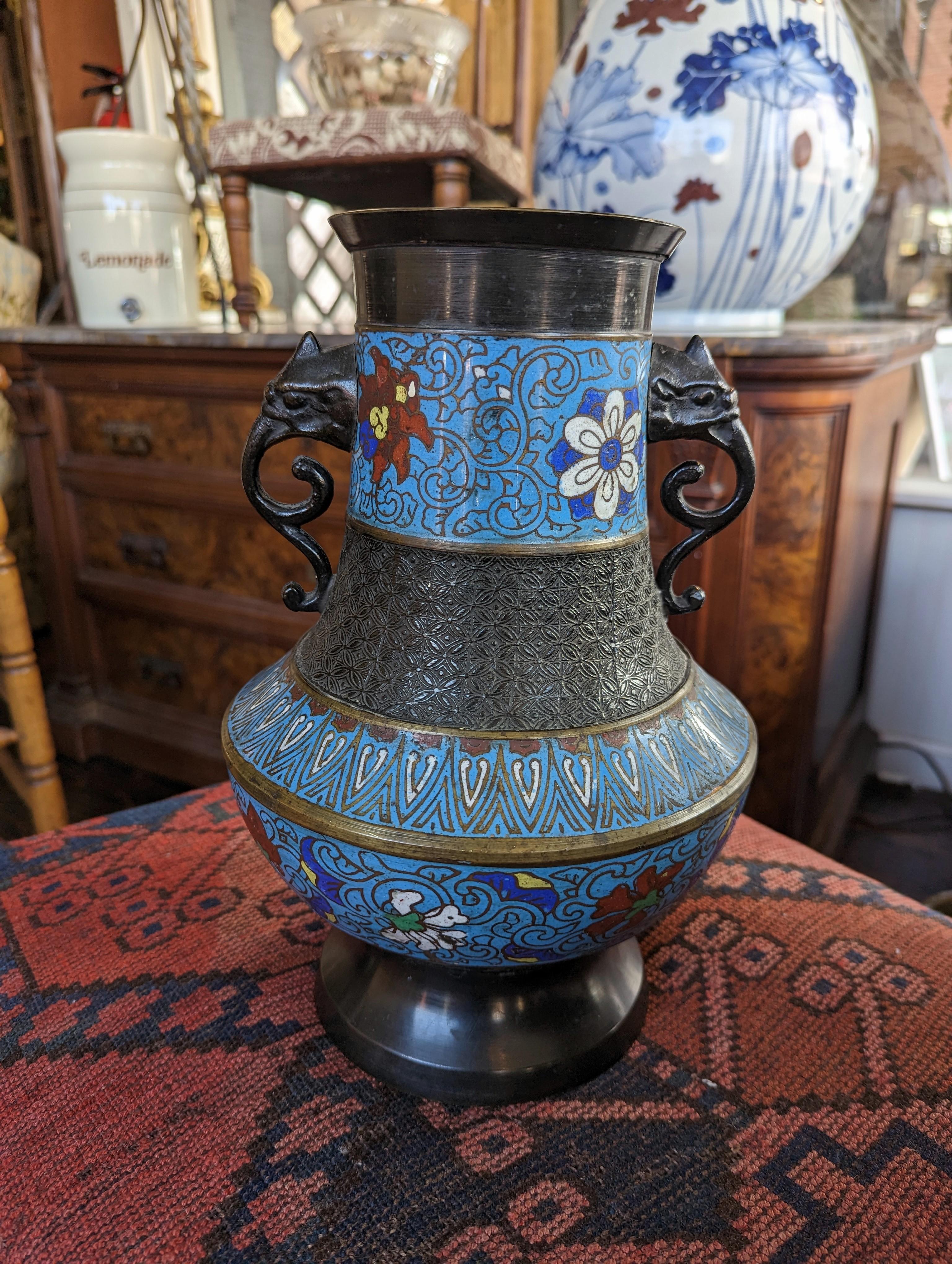 Beautifully crafted vintage Japanese urn shaped vase, featuring elephant head double handles in bronze and enamel. Colorful enamel adorns the vase with floral motifs, created using the champleve technique. Signed / marked 