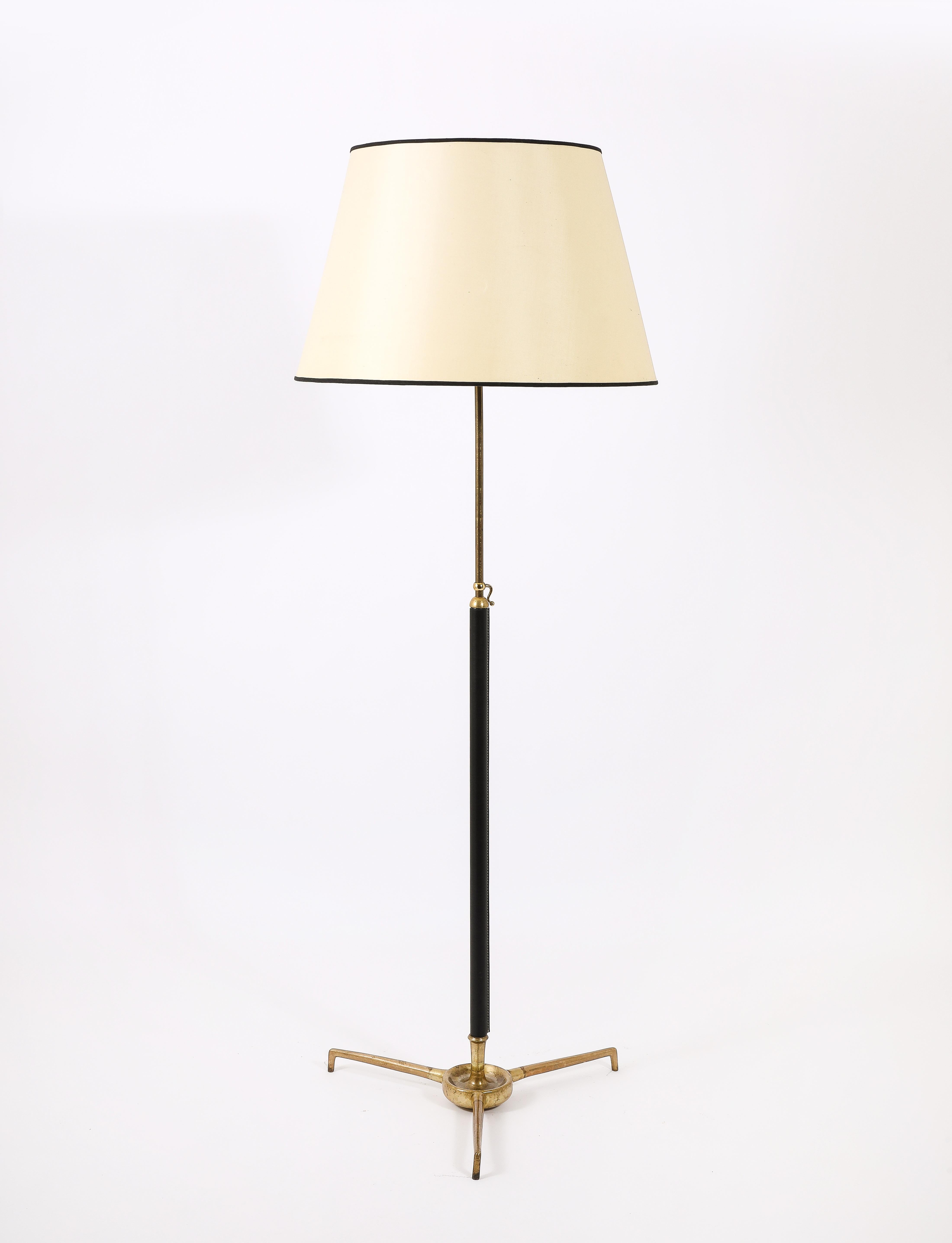 Large Bronze and leather floor lamp, a massive tripod bronze base supports the center stem, leather wrapped pole and an adjustable system that allows to raise or lower the shade from 60