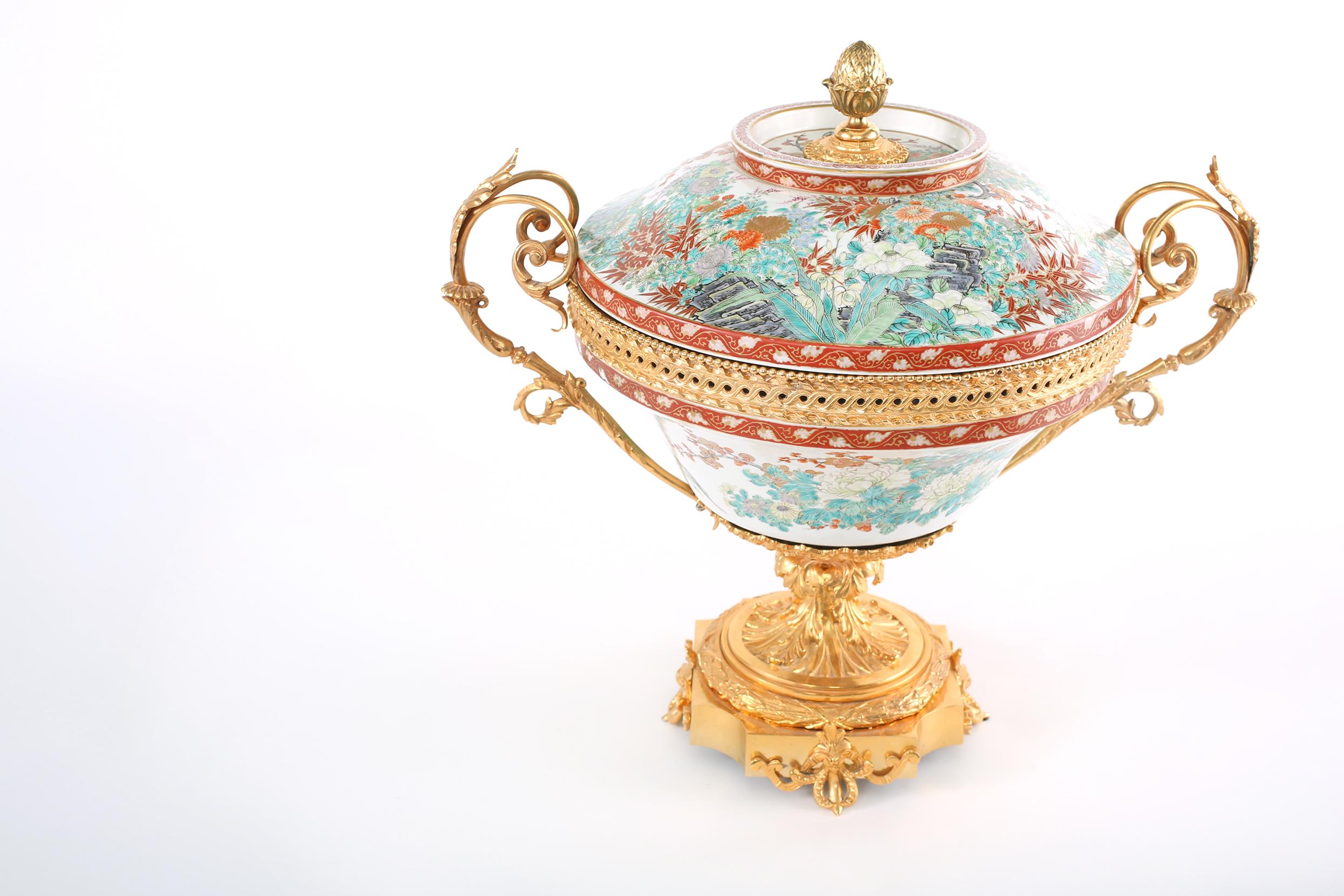Large gilt bronze mounted framed / Imari porcelain covered decorative centerpiece with side handles. The centerpiece bowl stands about 24.5 inches wide 
