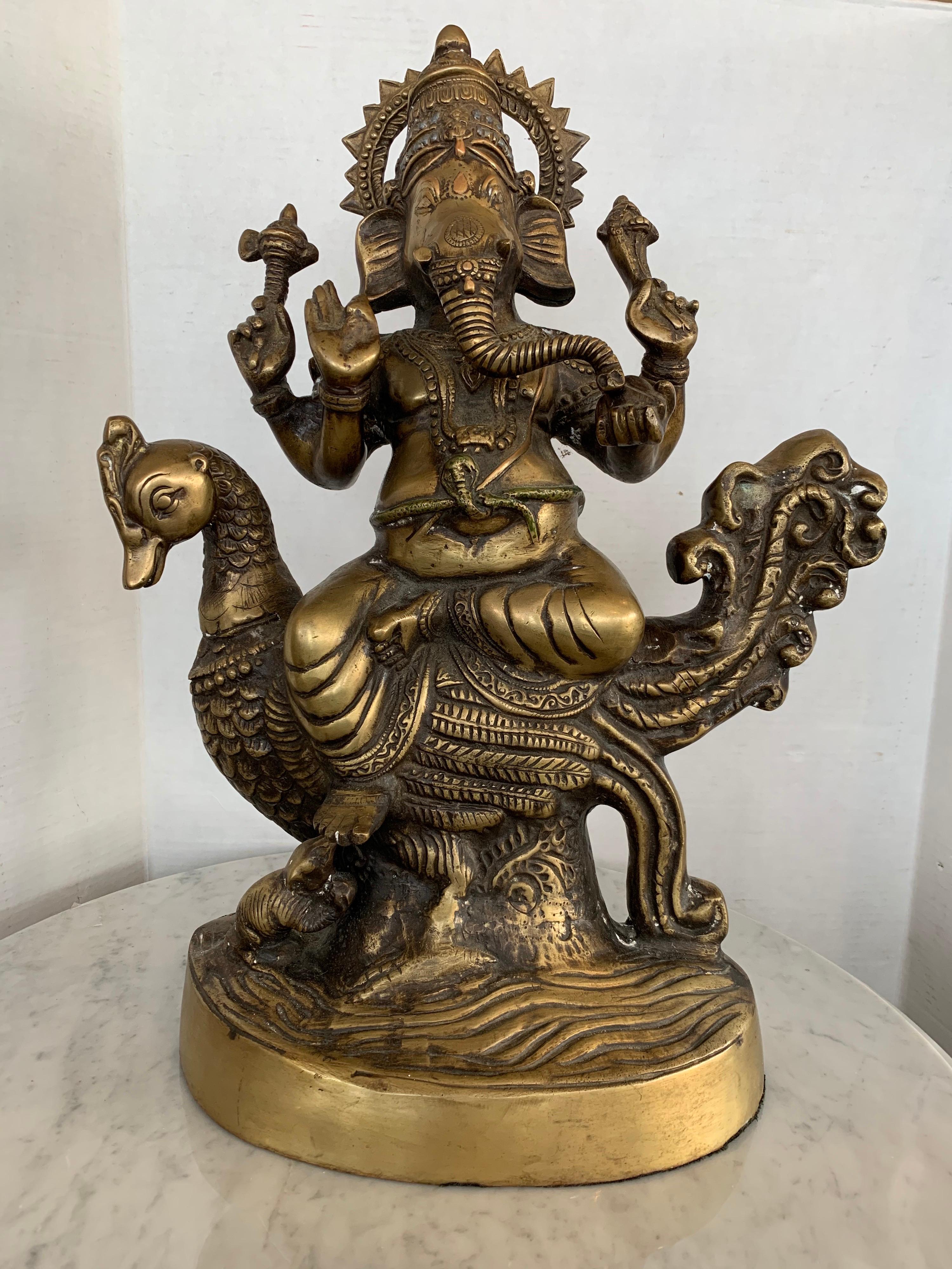This is a stunning bronze sculpture of Ganesha. This detailed sculpture depicts Ganesha, the Hindu god of success in a seated position. He is know in Asia to symbolize success, good luck and pervasiveness. He is elaborately dressed and holding a