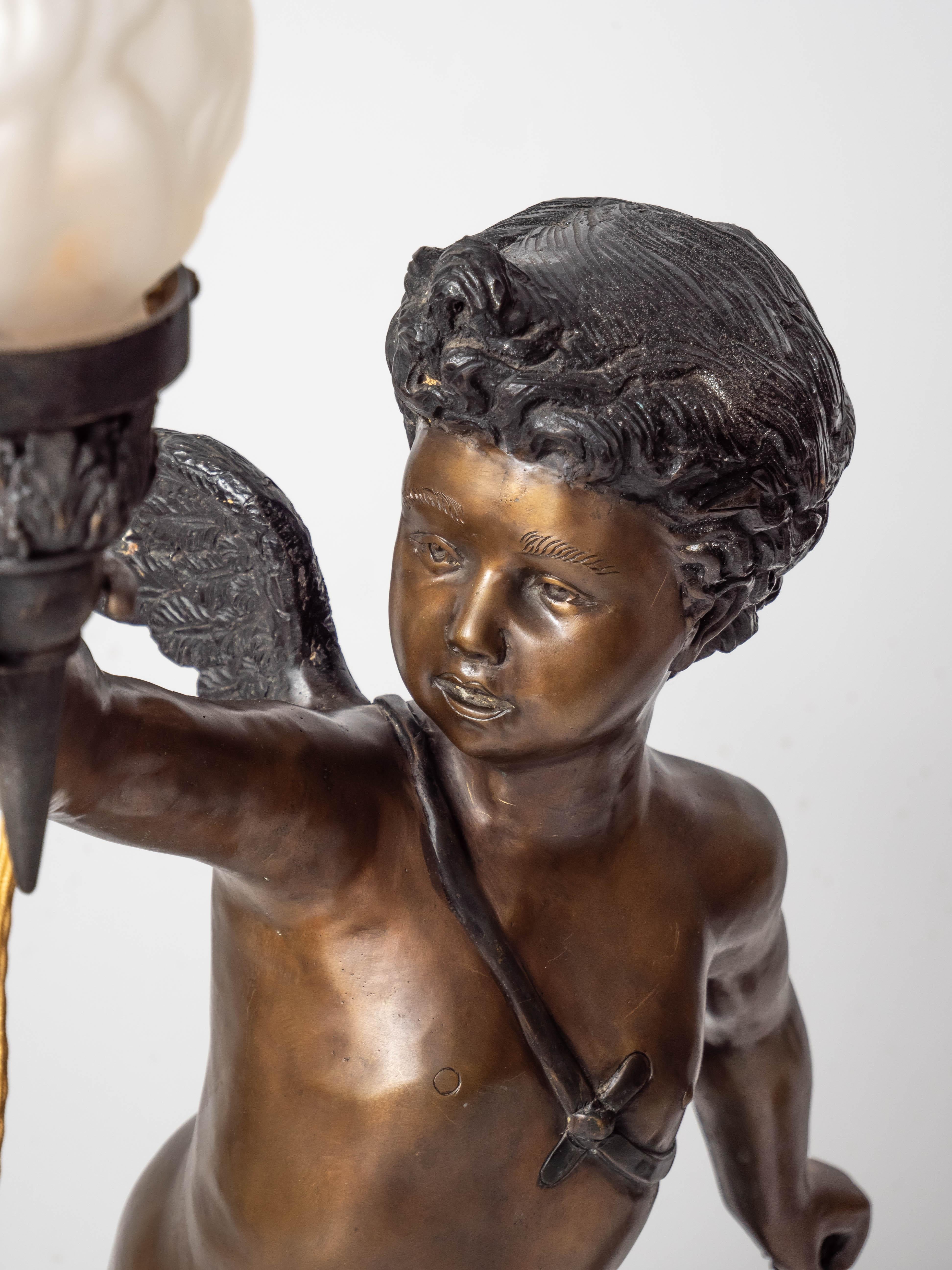 Large bronze statues of Cupids carrying a torch

Pair of cupids carrying a torch. The sculptures are heavy and detailed. Shades are handmade from frosted etched glass. The sculptures are newly electrified: new old-style power cords with gold-colored