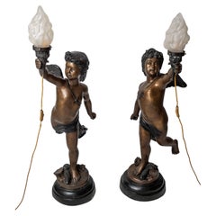 Large bronze statues of Cupids carrying a torch