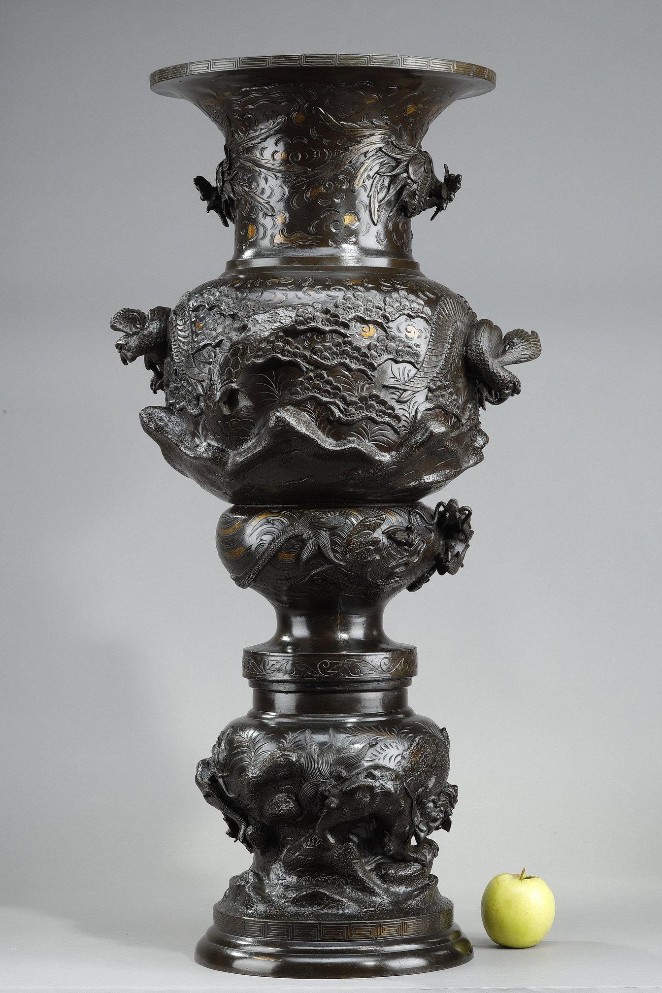 Very large sculpted bronze vase with a polyglobular body resting on a base decorated with a Greek frieze. The whole is decorated with chimeras, dragons, birds of prey and phnixes amidst a stylized décor of clouds, rocks, trees and plants. Meiji