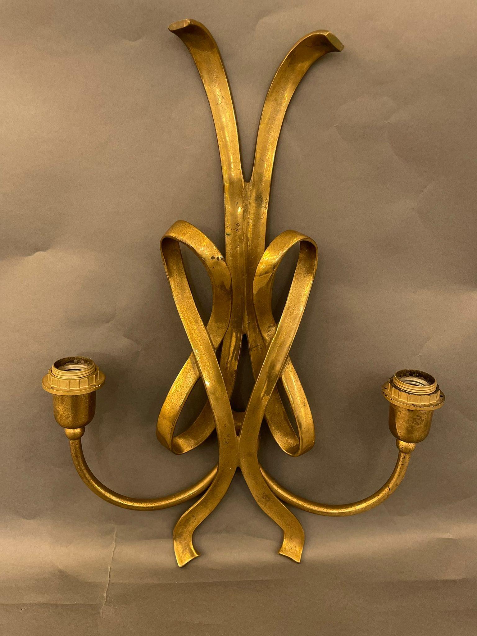 A unique large wall light in wrought bronze with a double ribbon decoration. France 1930s.