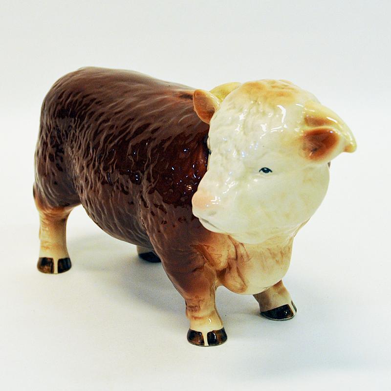 Large and beautiful natural looking countryside farm cattle Hereford bull figurine of ceramic, England, 1950s. Made of glazed ceramic and painted in white and brown colors. Would look great in the windshield, table, shelf or just on the Livingroom