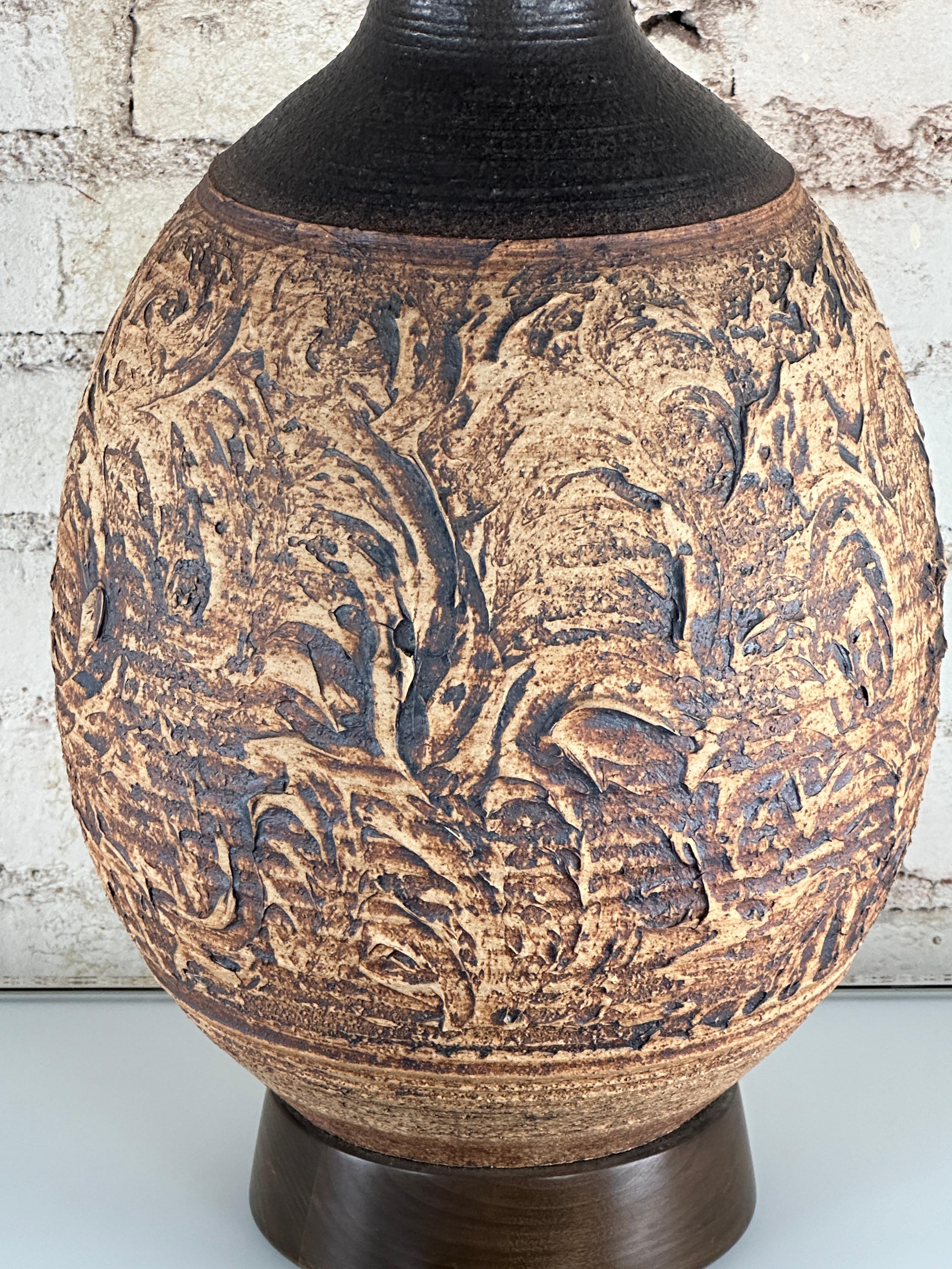 Hand-thrown brown ceramic large table lamp on a walnut base table lamp in the style of potter Bob Kinzie for Affiliated Crafstmen, circa 1960s.

Bob Kinzie is one of the most amazing throwers.
In the early 1960's, he and two friends established a