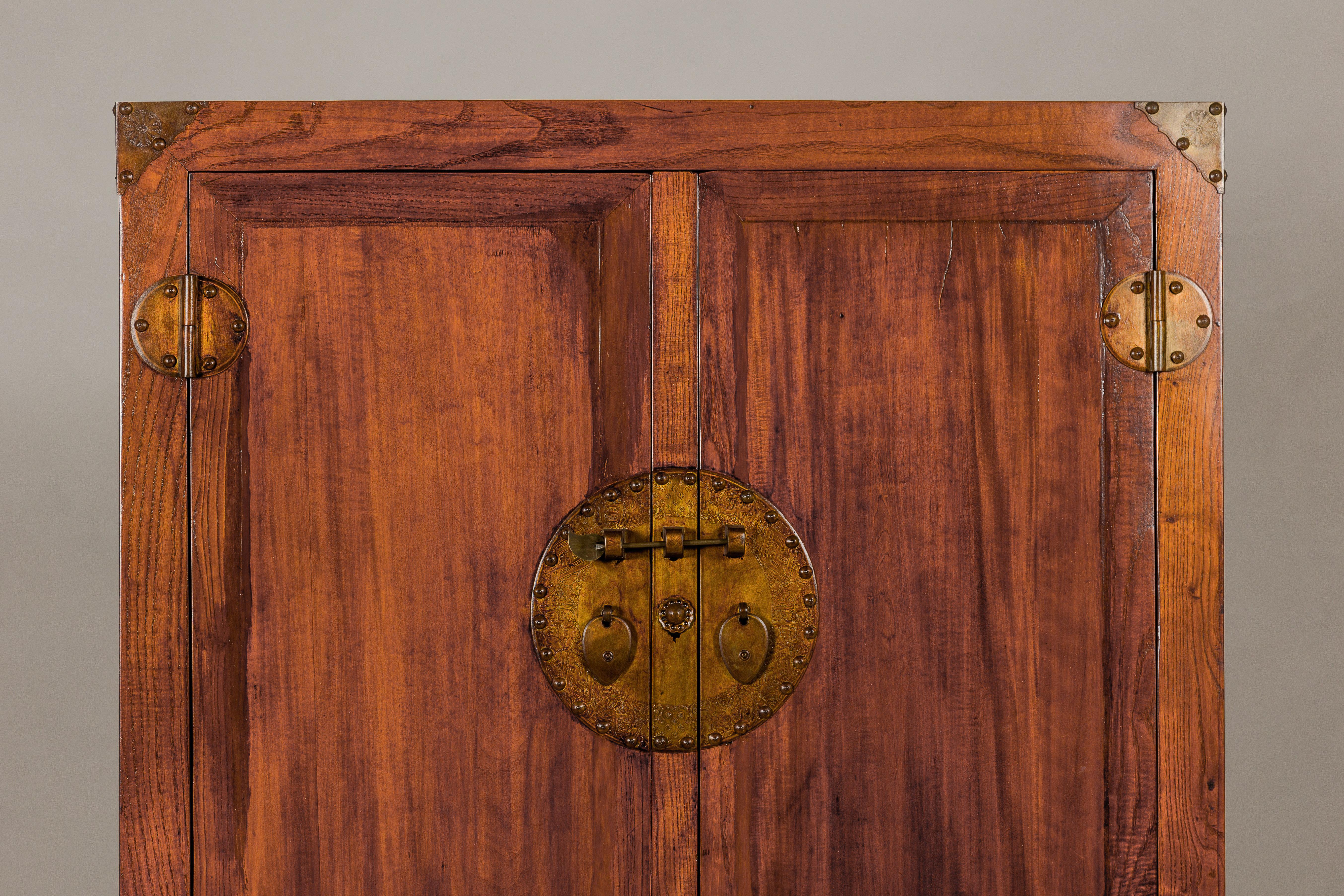 Qing Grande armoire en bois d'Elmwood laqué Brown avec jupe sculptée et quincaillerie en laiton en vente