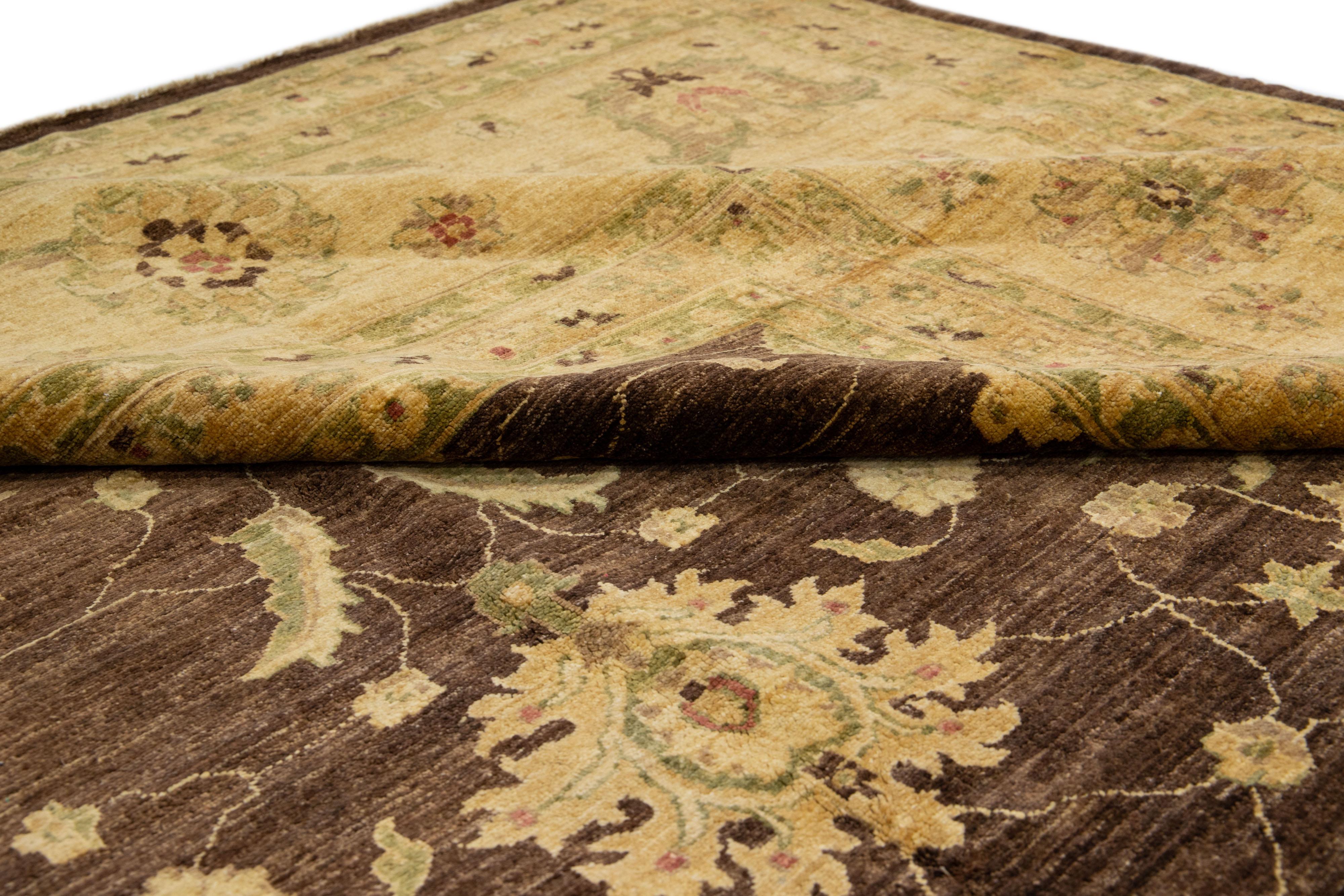 Beautiful oversize Paki Peshawar hand-knotted wool rug with a brown field. This modern rug has a beige and golden frame with green accents in a gorgeous all-over Classic vine scroll and a palmettes motif.

This rug measures: 17'8'' x 28'8