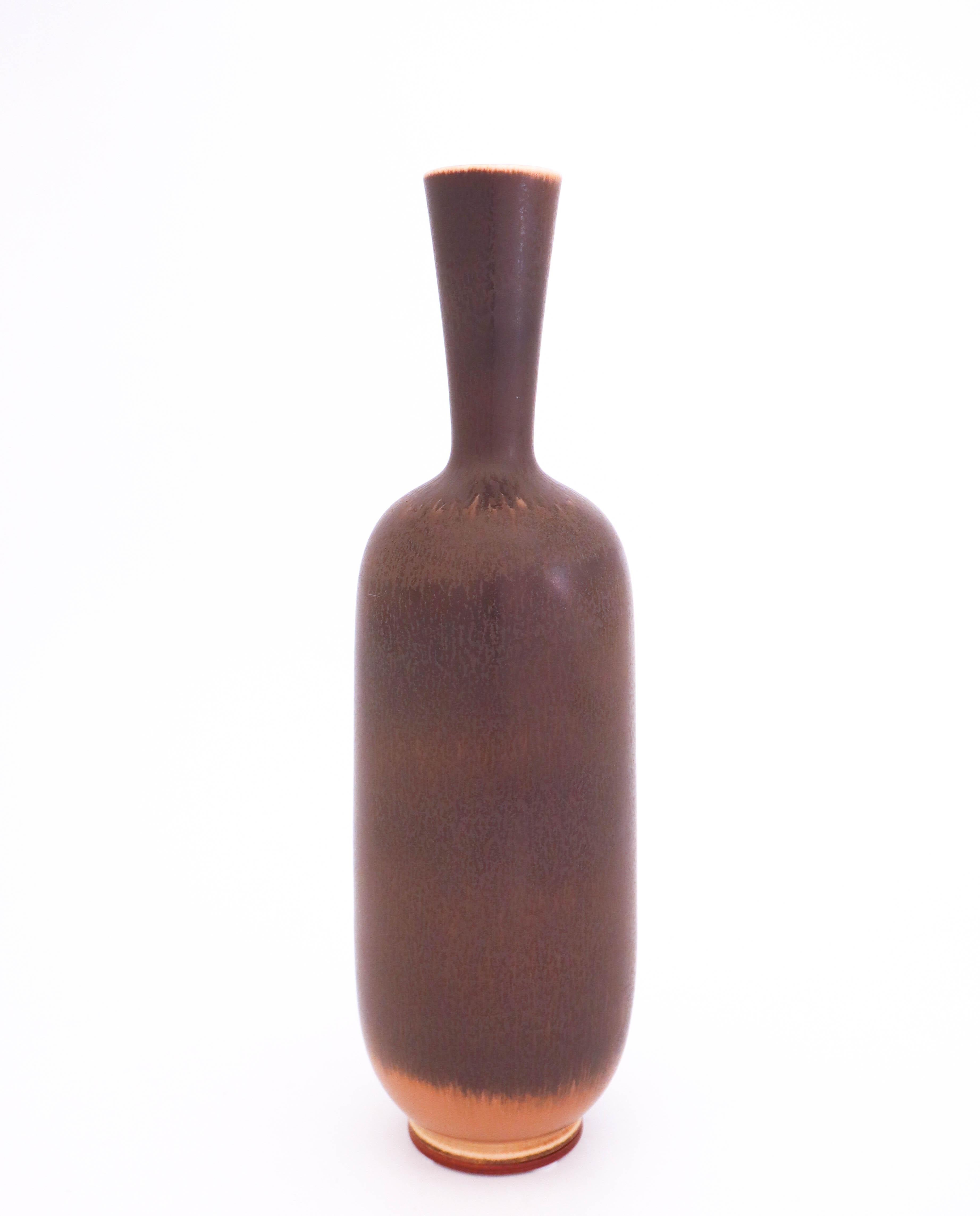 A large brown vase designed by Berndt Friberg at Gustavsberg. It is 33.5 cm high and 9.5 cm in diameter and in very good condition except from a tiny mark in the glaze. It´s marked as the picture shows, this one is produced in 1948.