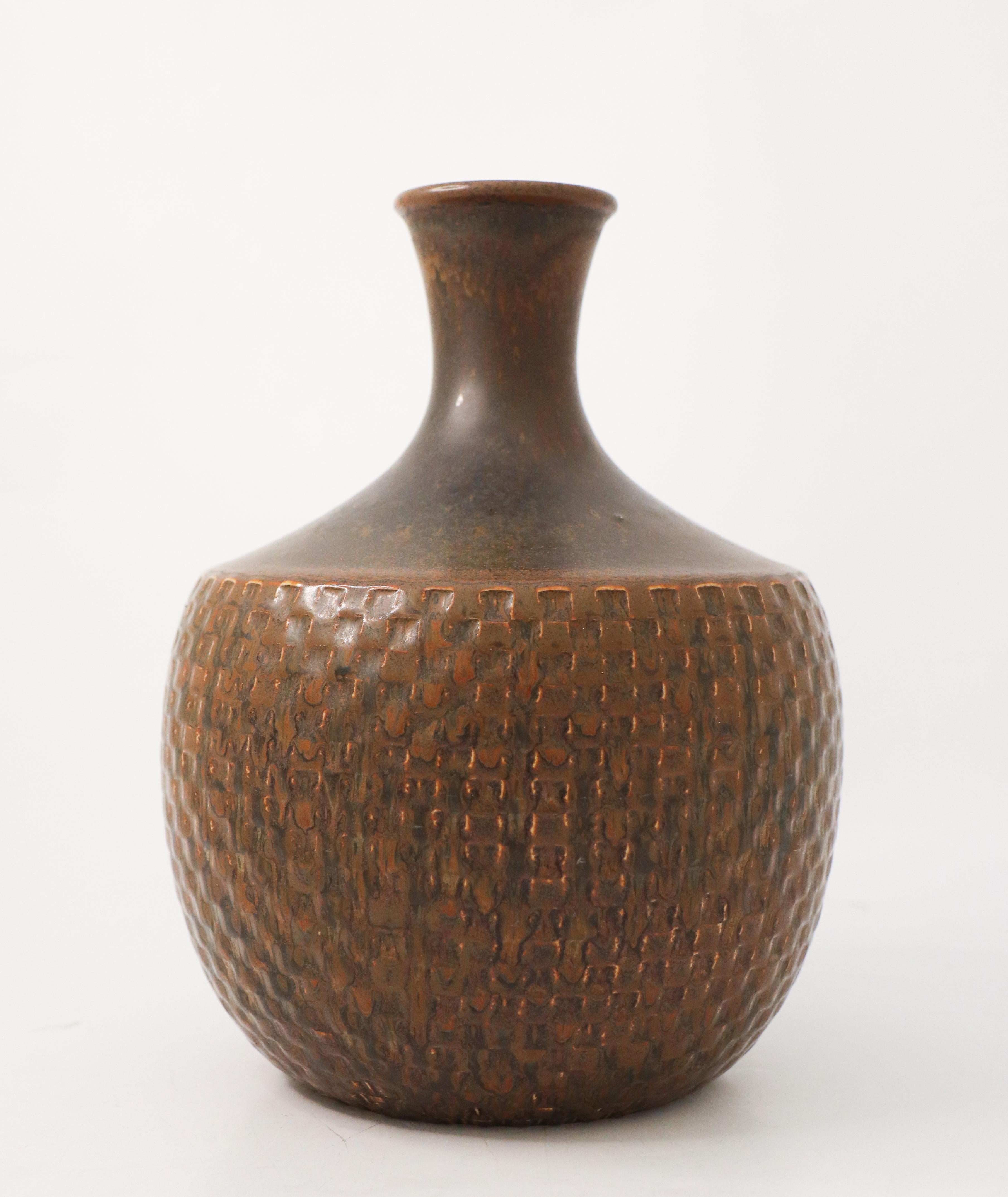 A large brown stoneware vase with a relief decor designed by Stig Lindberg at Gustavsberg. It is 22 cm high and in very good condition. This vase was designed in 1963.