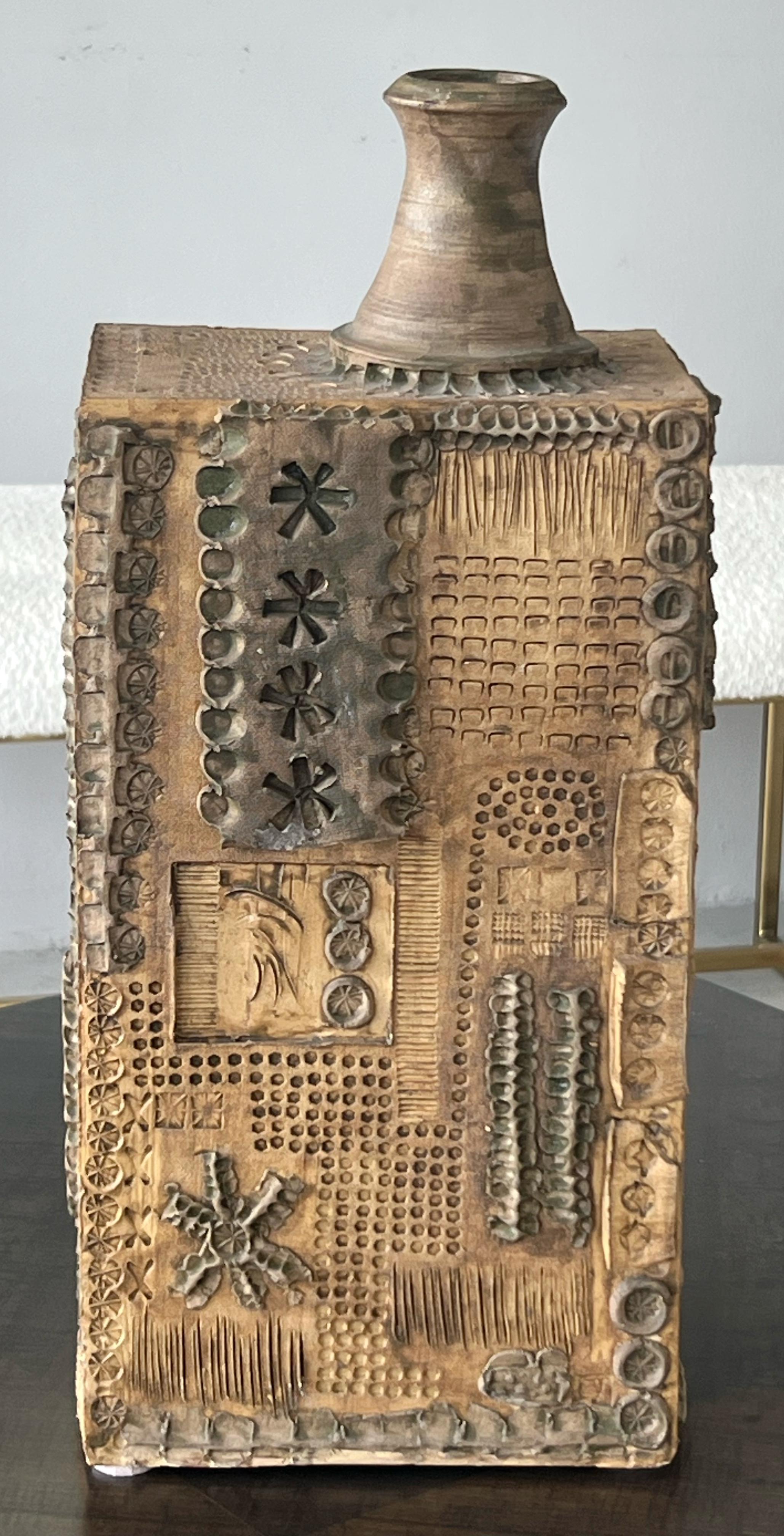 A very large chimney vase. The brutalist decoration is all over with intaglio areas and applied elements. 