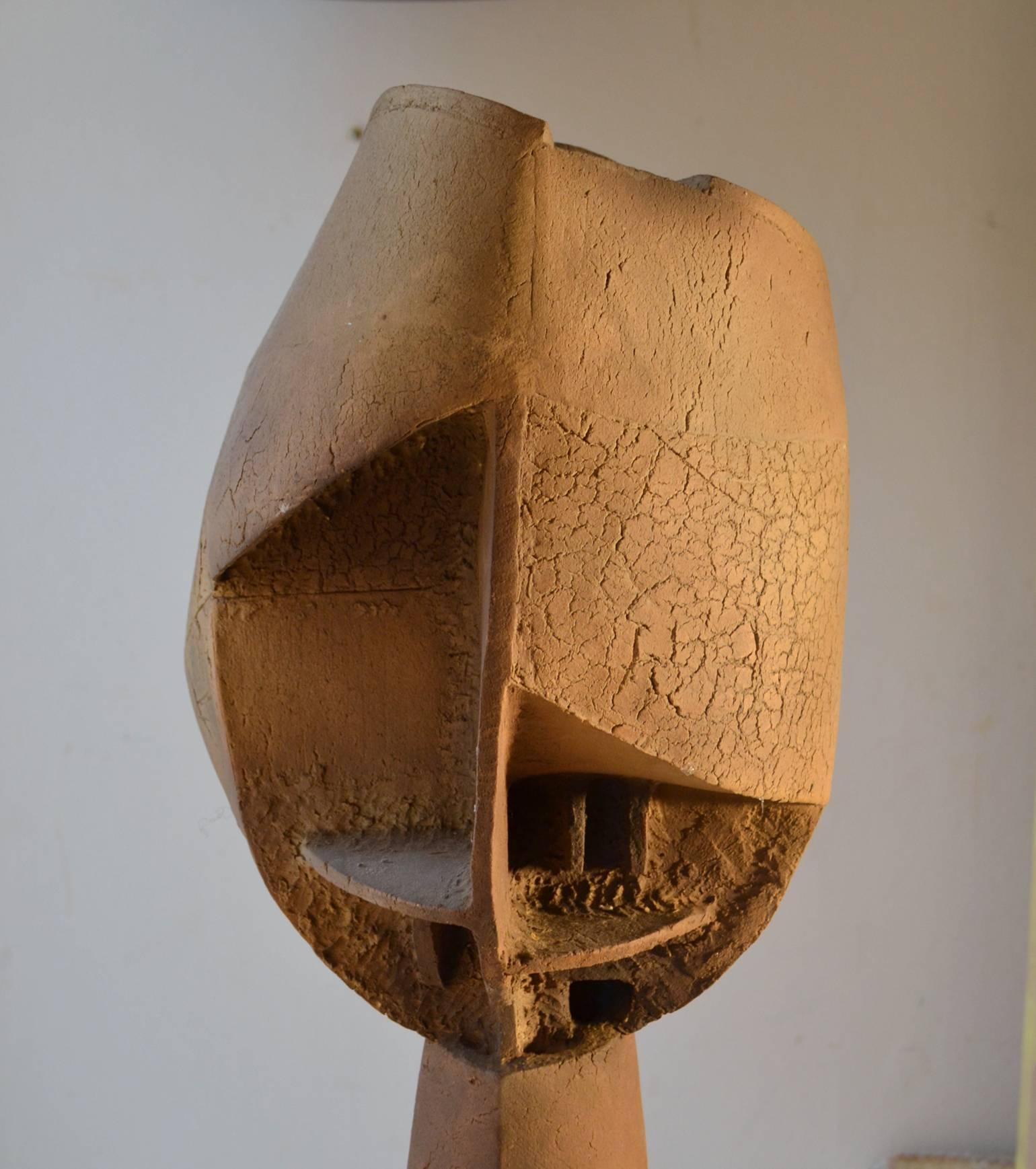 This very tall abstract deconstructed bust sculpture in Cubist style is also brutalist in its execution. It has many faces, from every angle it looks different. The terra cotta sculpture is constructed in slabs of clay by a Scottish artist in the