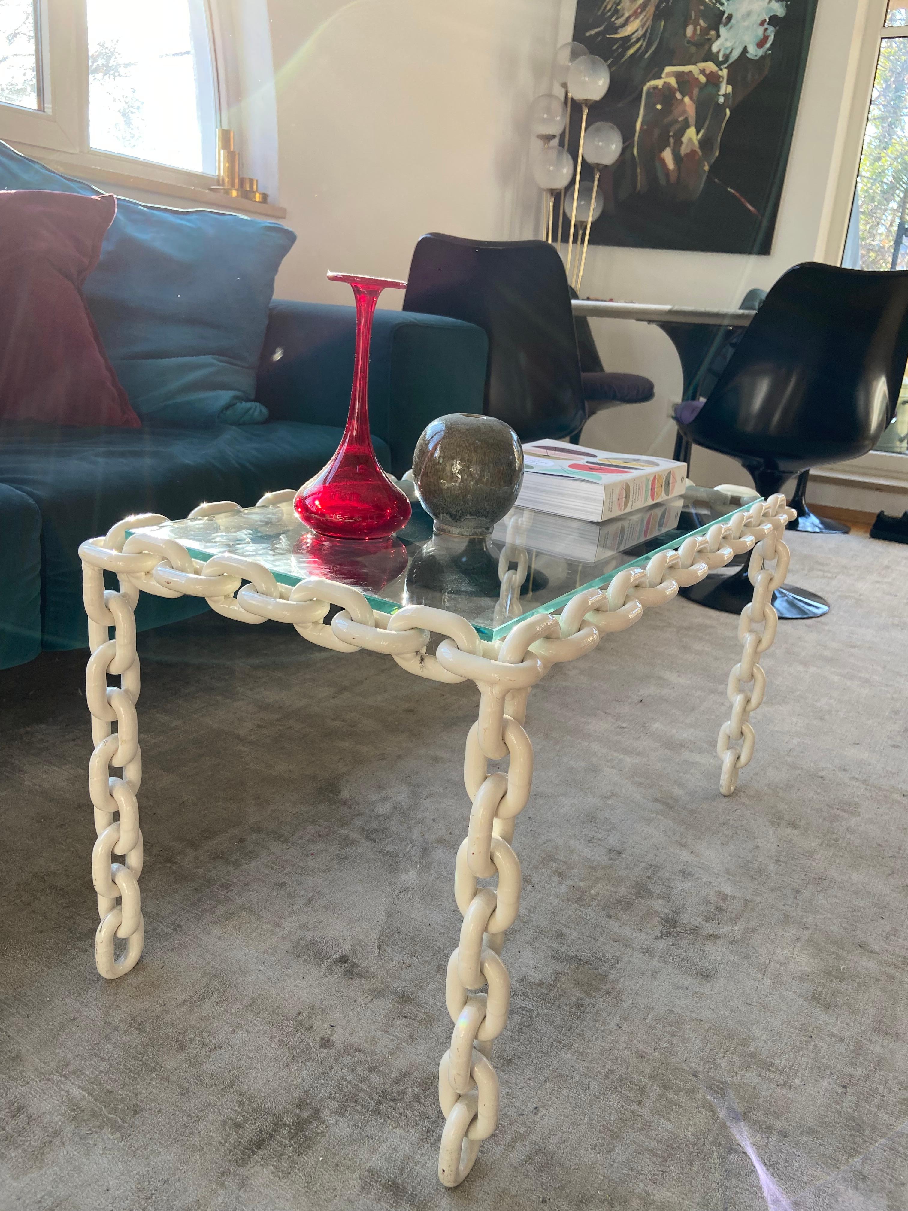 This coffee table is a bold statement piece and has a gravity defying design in true brutalist fashion! 

The raw, industrial aesthetic is softened by the white lacquer and the fact that the chain links have no studs, separating this table from