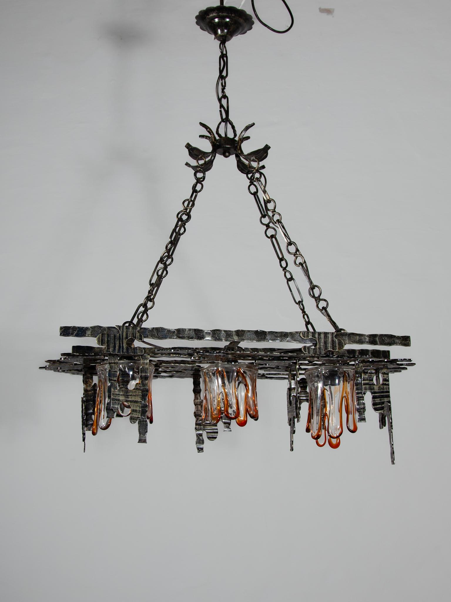 Rare unique rectangular wrought iron brutalist chandelier with 3 caps mouth blown clear glass and amber designed by the following designers Tom Ahlström & Hans Ehrlich,Sweden, 1970s.