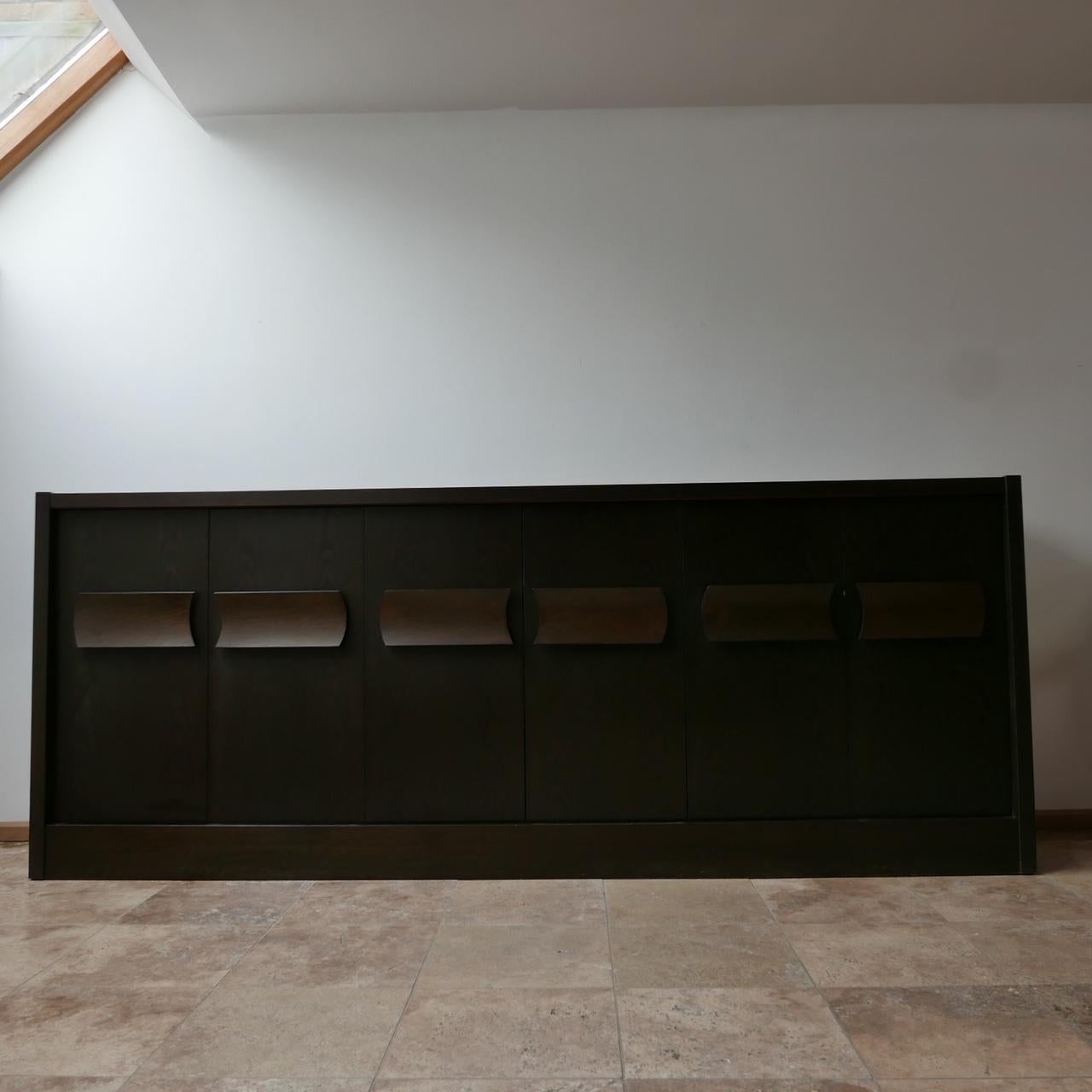 A large six door credenza or sideboard. 

Belgium, c1970s. 

A scarcer model than the ones done by De Coene. 

Simple turned handles. 

Veneered and stained wood. 

Good condition, there are some small nicks to the base of each