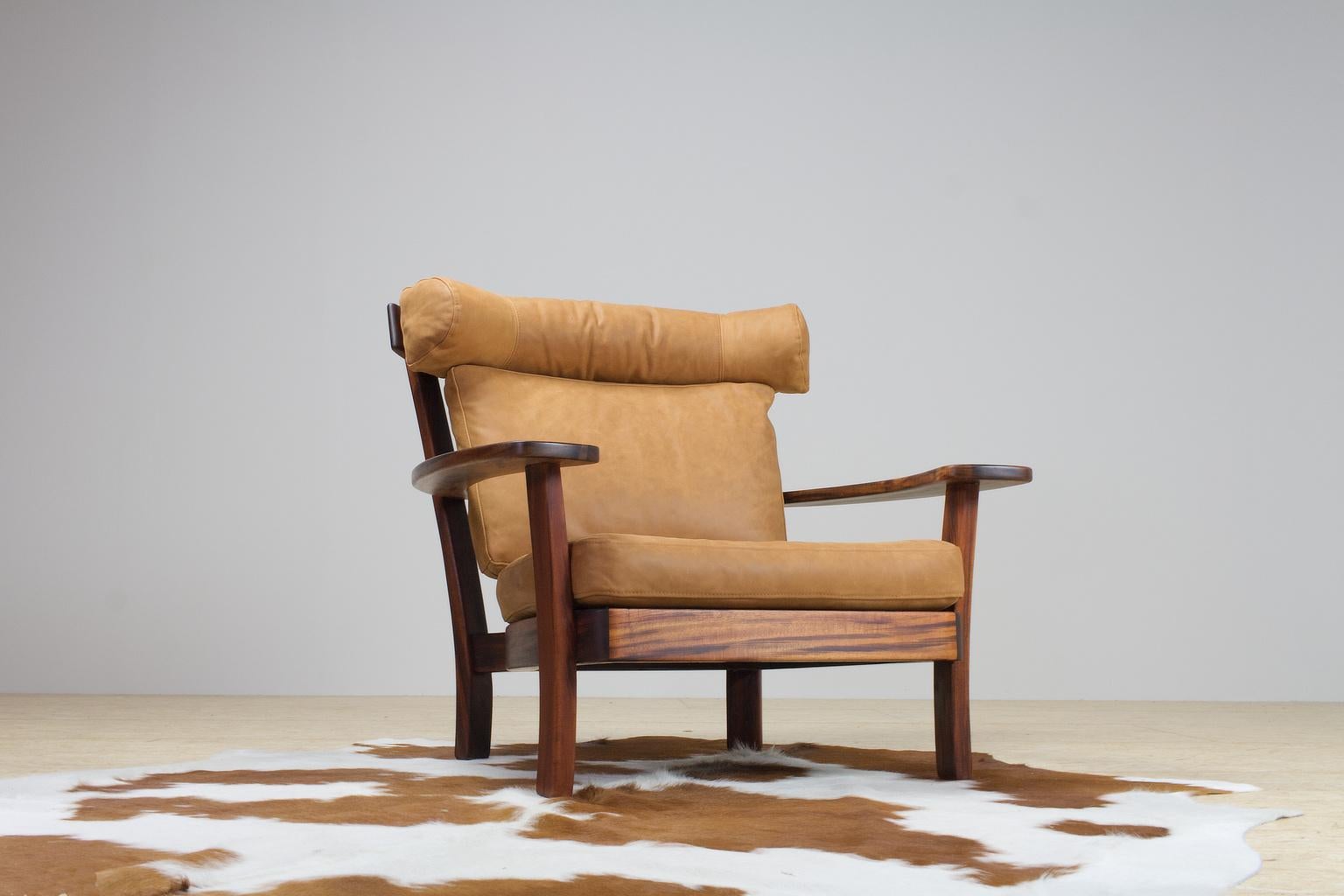 A re-upholstered leather 1960s large and a bit Brutalist - yet very comfortable - lounge chair. This piece feels connected to the Ox design by Hans Wegner, yet it also has a hint of South American playfulness that is characteristic in designs by