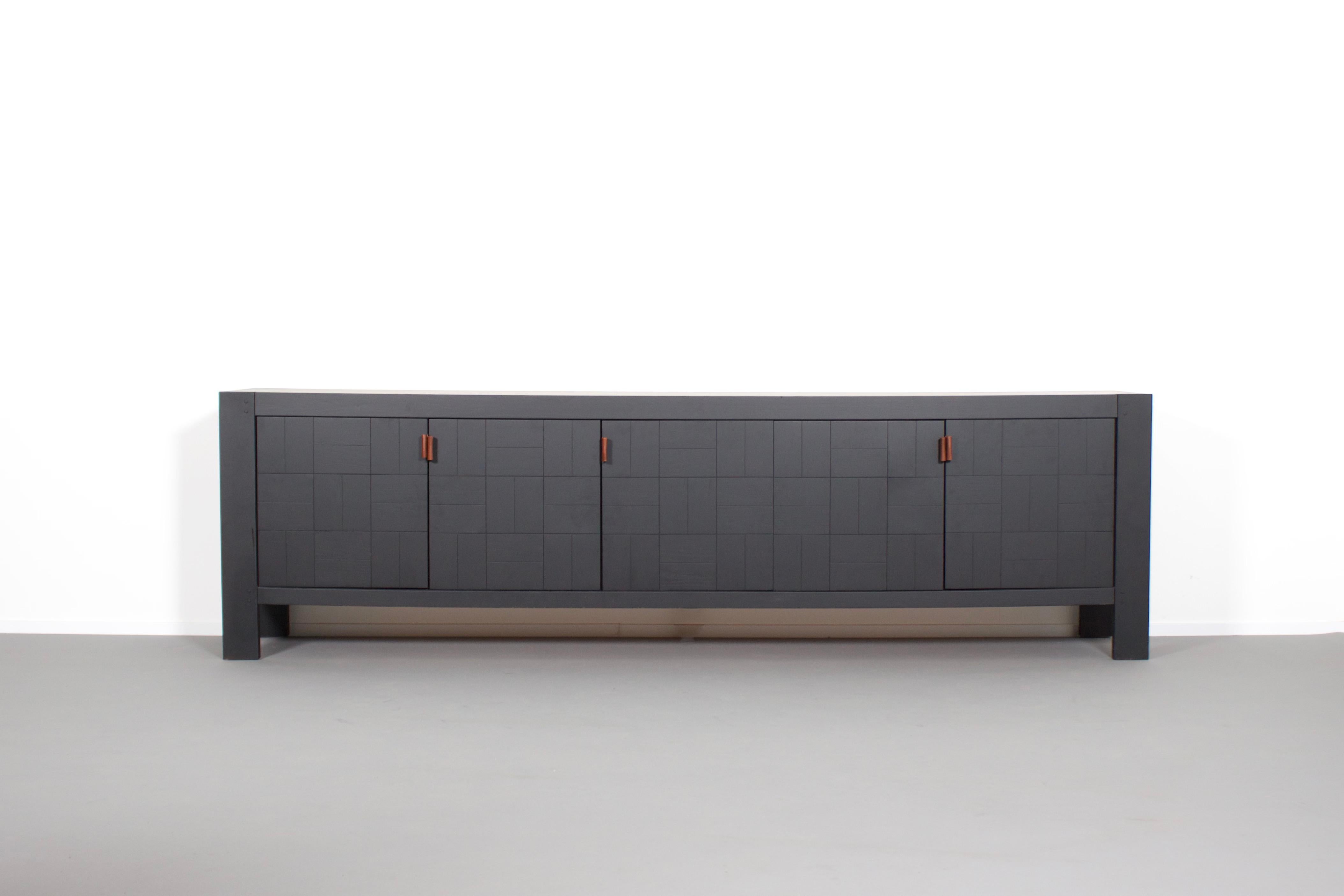 Impressive Brutalist sideboard in very good condition.

Made in Belgium in the 1970s. 

The sideboard is executed in black oak.

The graphic doors are finished in a way that a patchwork is created with a combination of horizontal and vertical