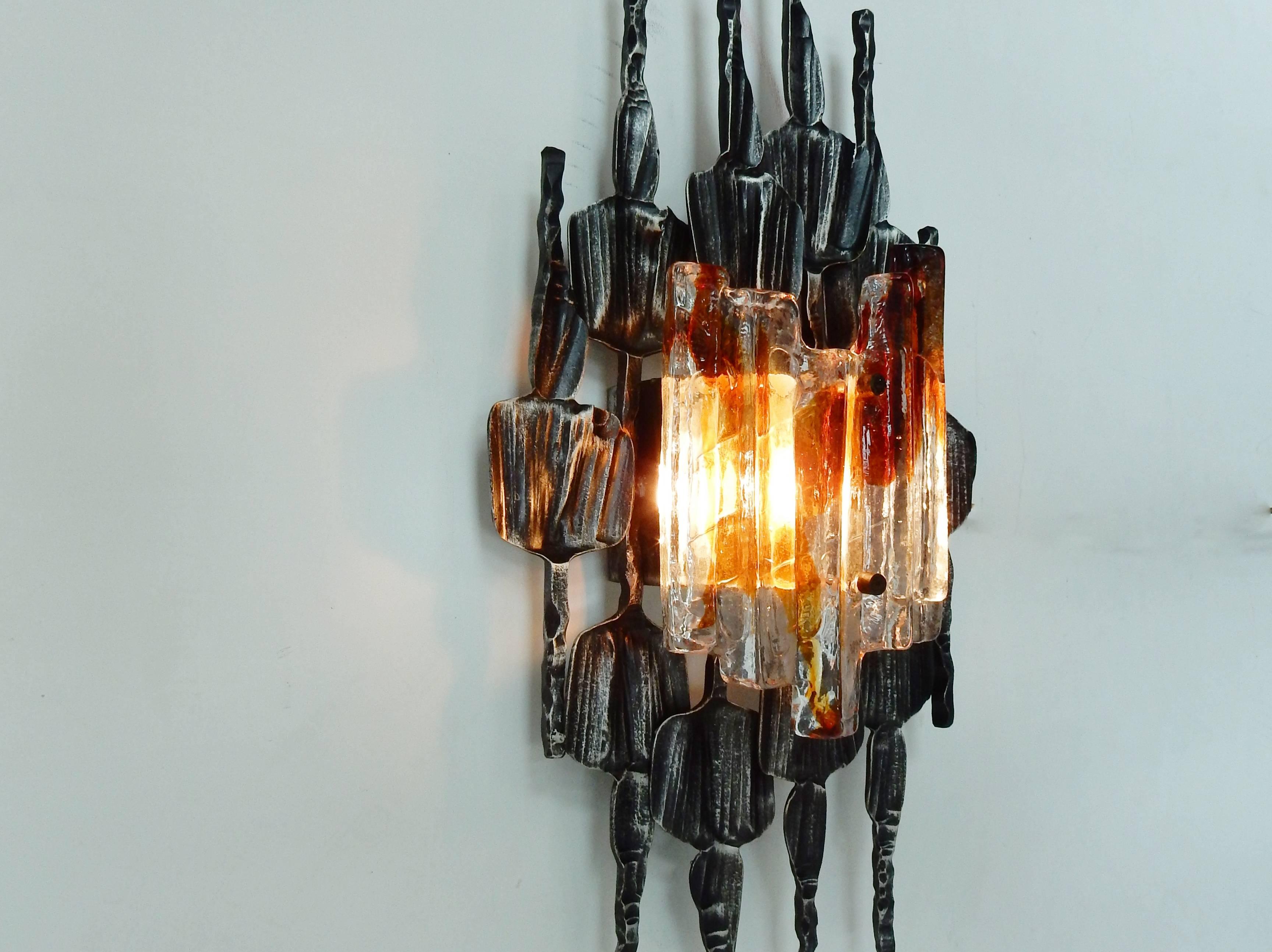 This midcentury wall light is made from hand-wrought anthracite grey iron and thick clear ice Murano glass with and amber tones.