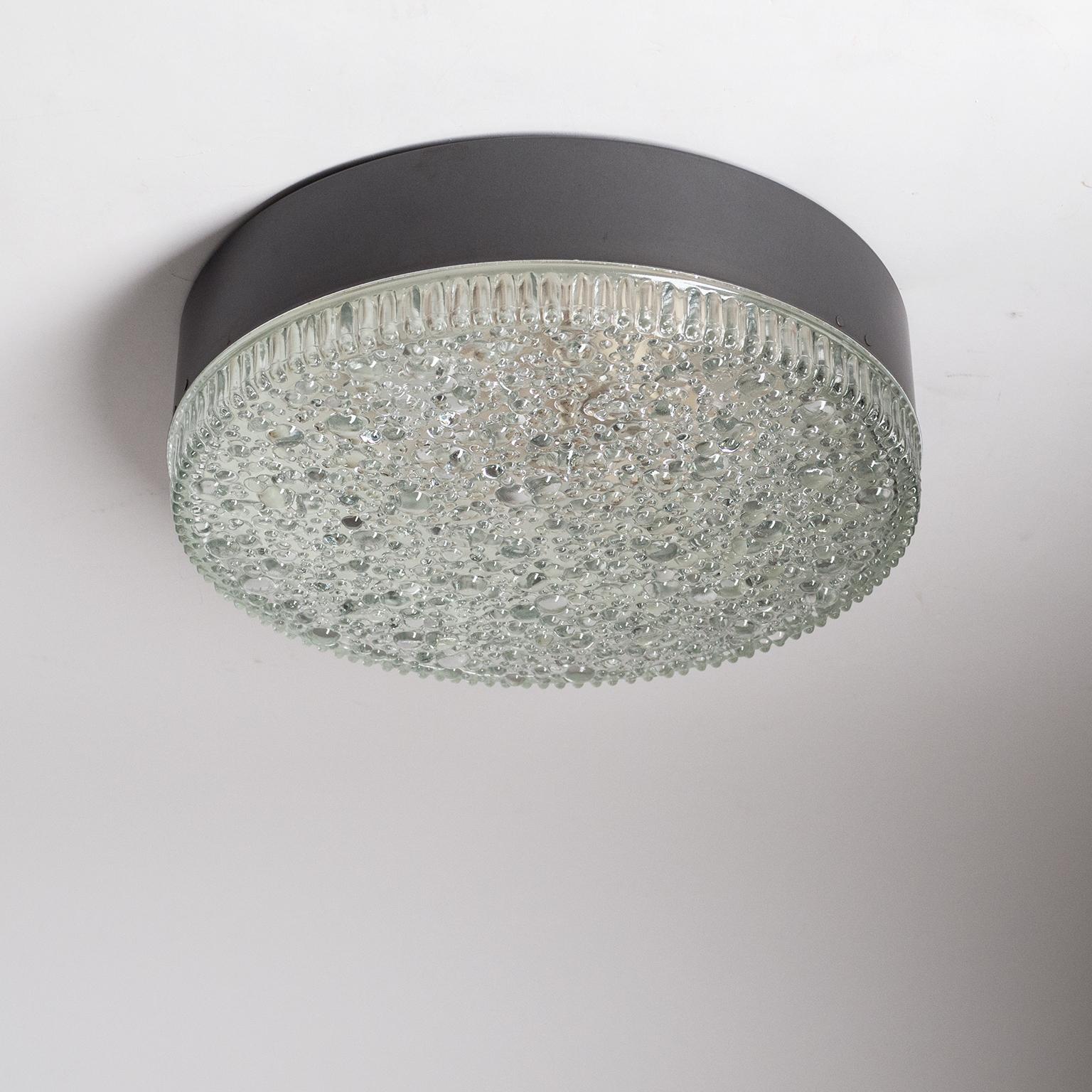 Large bubble glass flush mount (model A230) by Staff, 1960s. A large and heavily textured glass diffuser with 'bubbles' of varying sizes is mounted on a dark grey-metallic lacquered metal base. Good original condition with some discoloring and wear