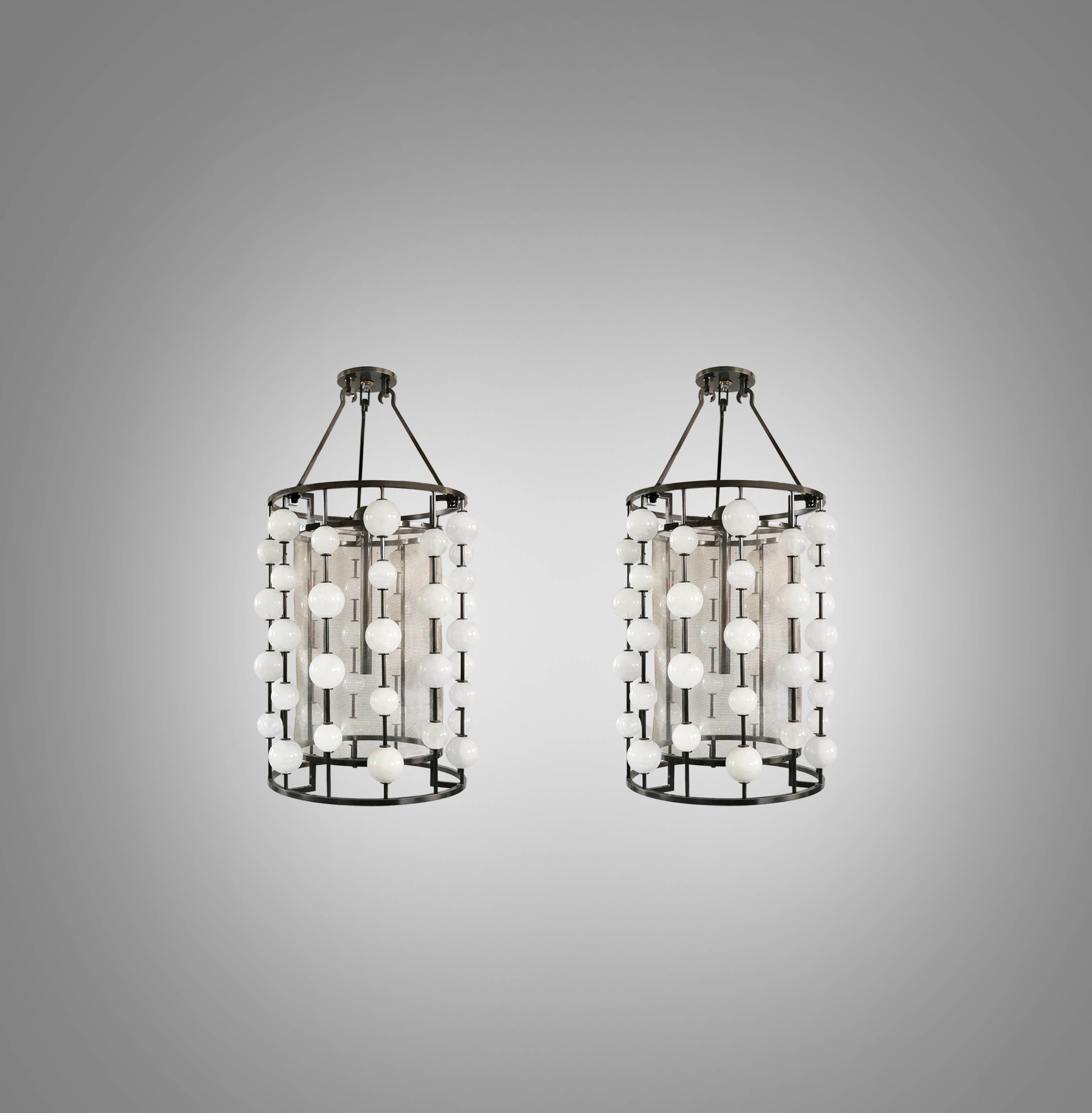 Pair of rock crystal bubble pendant lights with antique brass frames. Created by Phoenix Gallery, NYC.
Two sockets installed. E26 base light bulbs. 80w long tube lightbulb. 160w total.
Height can be adjustable.