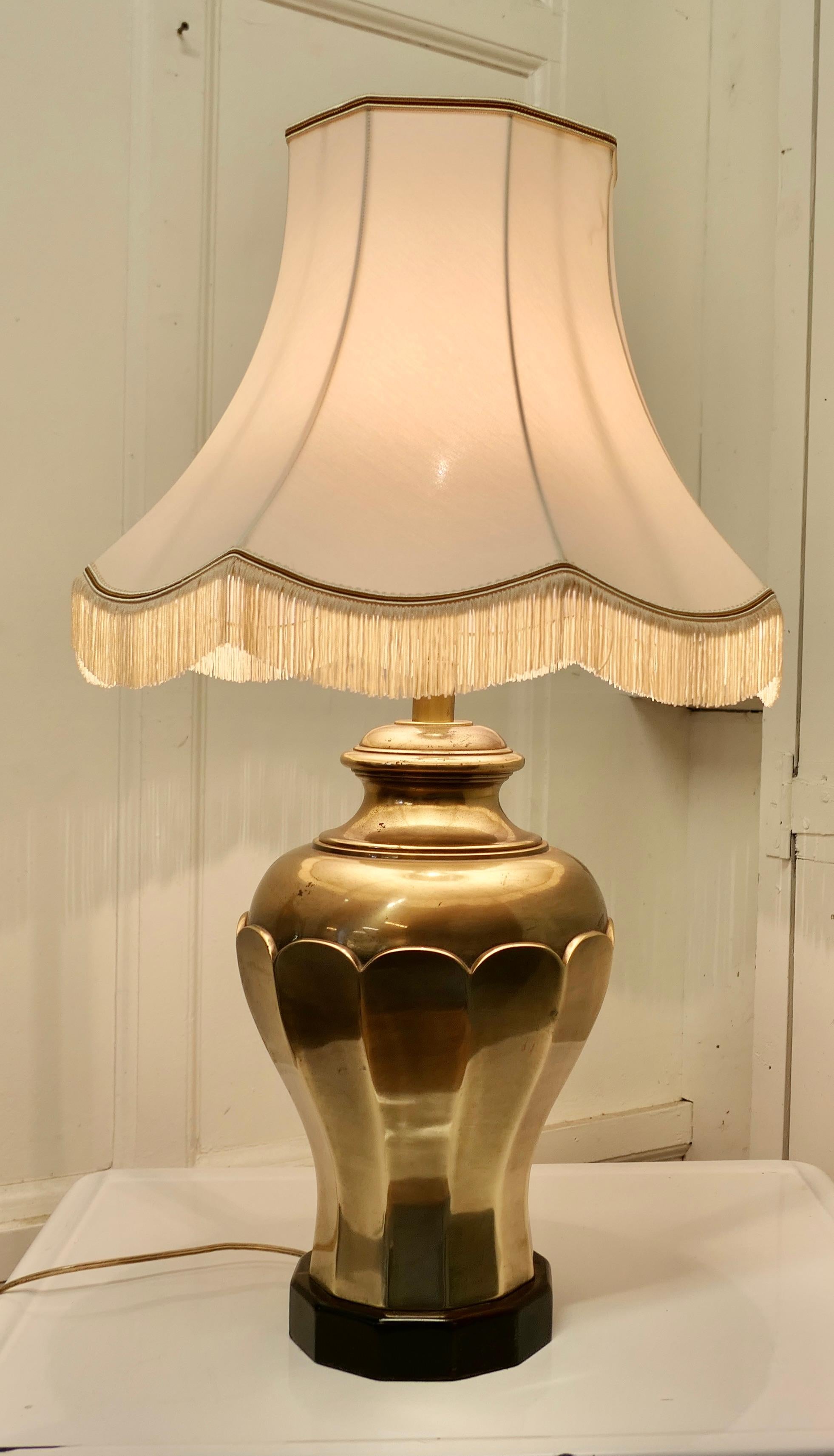 Large Bulbous brass table lamp 

This is an unusual Lamp has a large brass base set on a wooden plinth and has scalloped fringed lampshade
The lamp is fully wired and in good condition, a statement piece in any room
The lamp is 29” tall, 10”