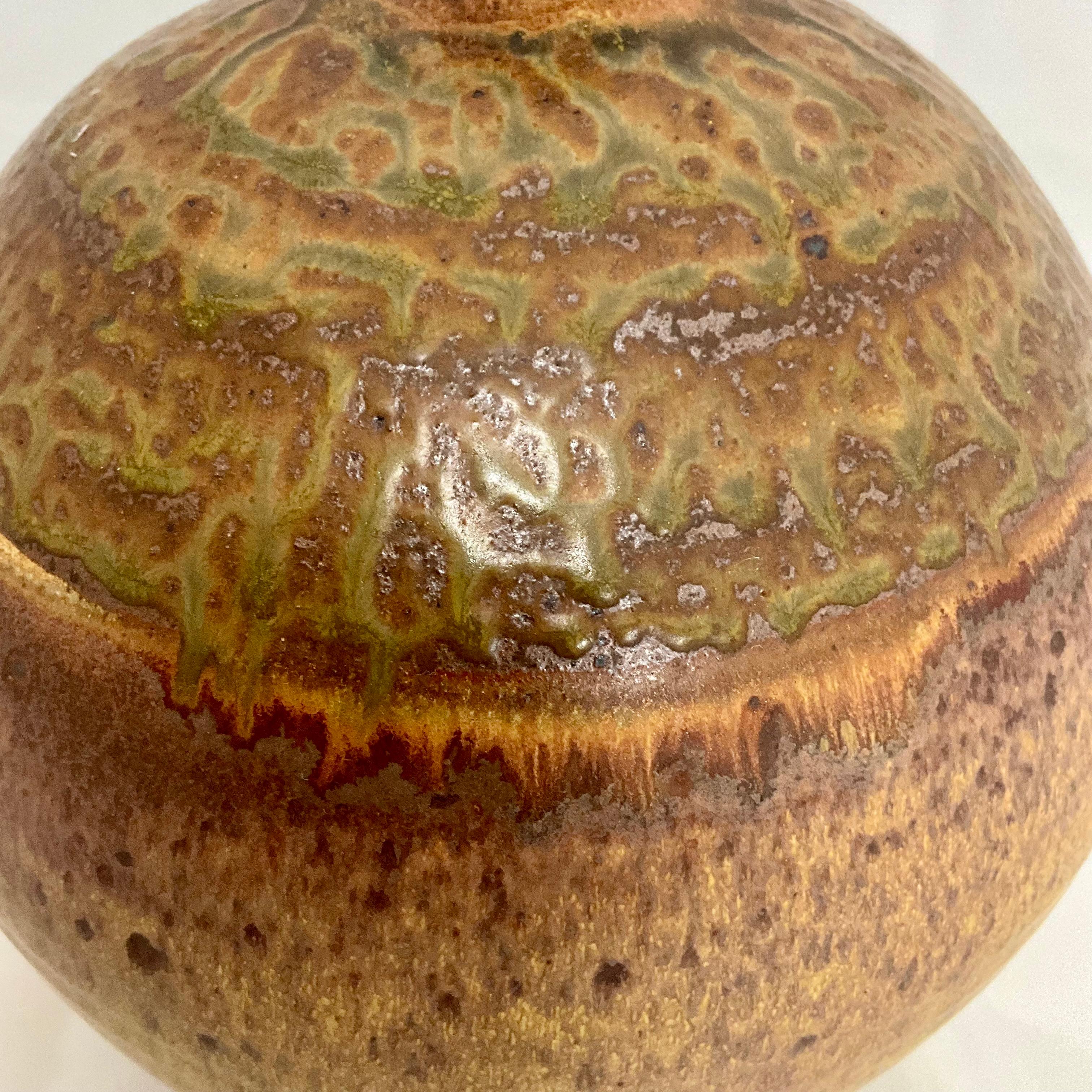 Grande vaso in Studio Pottery della metà del secolo, realizzato a mano in tonalità di senape, marrone e verde, con colori che si scuriscono man mano che si sale verso la parte superiore del vaso. Questo pezzo è firmato sul lato inferiore con una