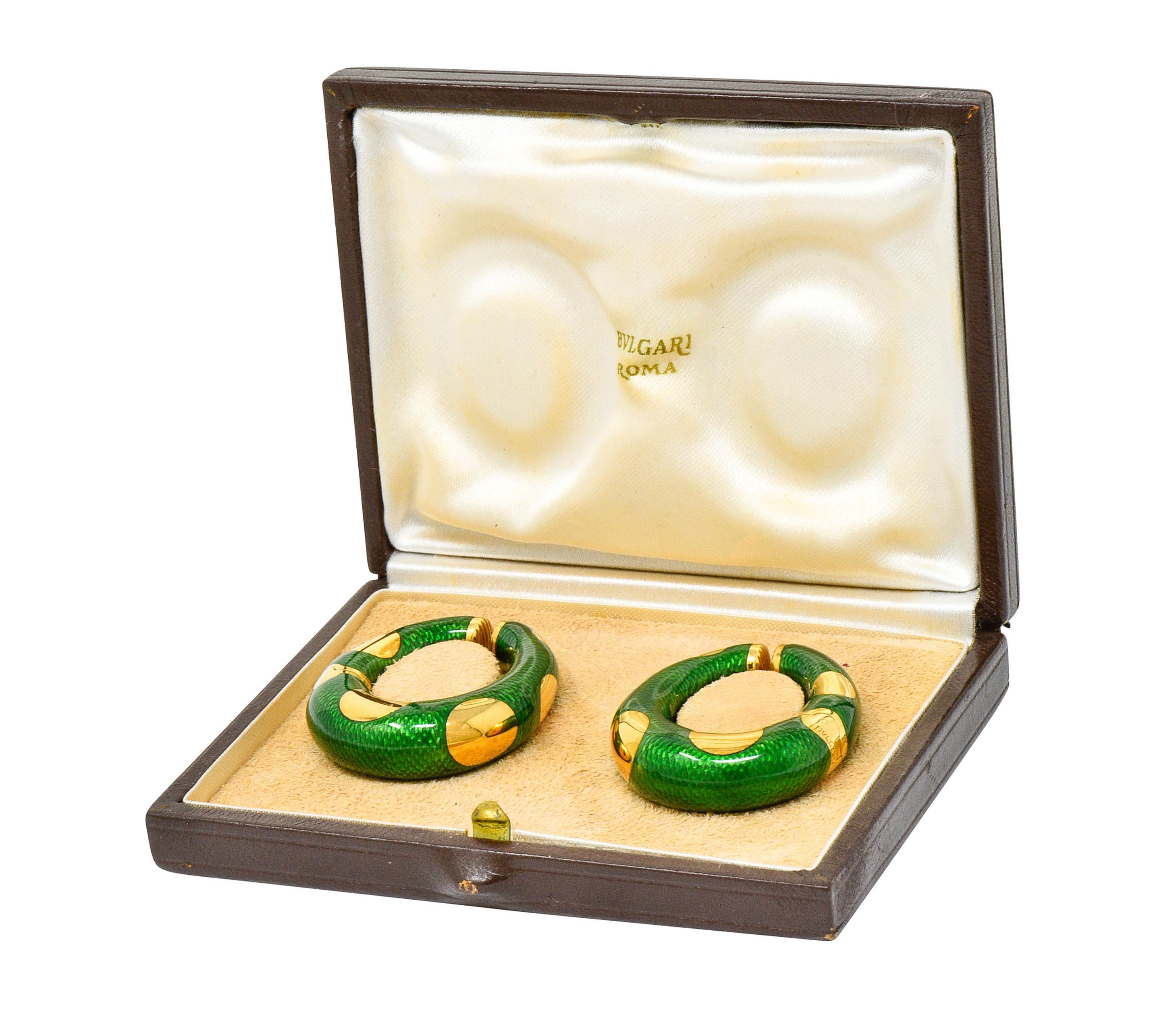 Earrings are designed as puffed oval hoops with a polished gold circle motif throughout

Featuring a deeply stippled texture glossed over with bright green enamel, exhibiting no loss

Completed by spring hinged closure

Fully signed Bvlgari