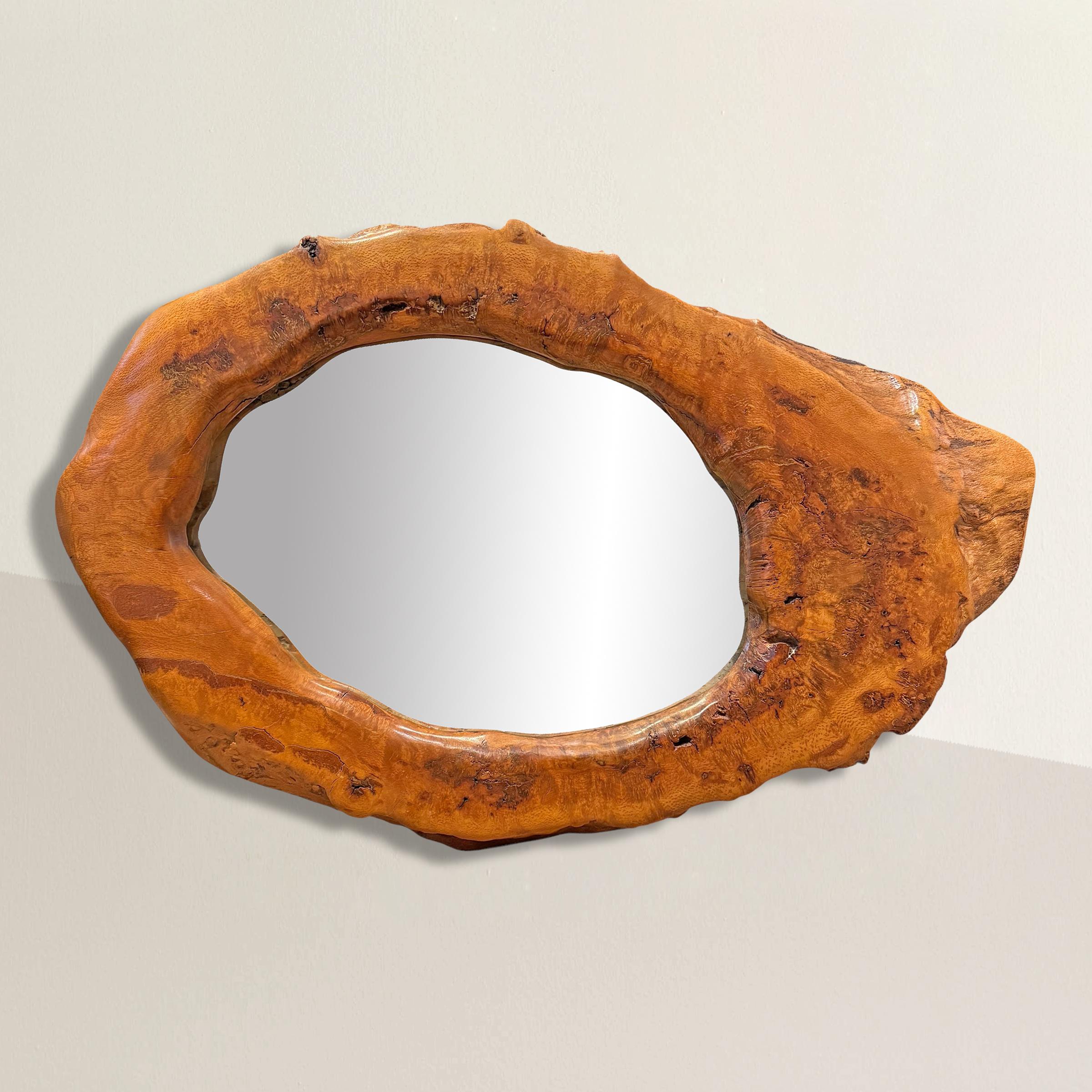A true celebration of nature’s artistry, this breathtaking American mirror is framed with a single, ovoid slice of tree burl—an organic masterpiece that feels both raw and refined. The richly grained wood shimmers with a deep, glowing patina,