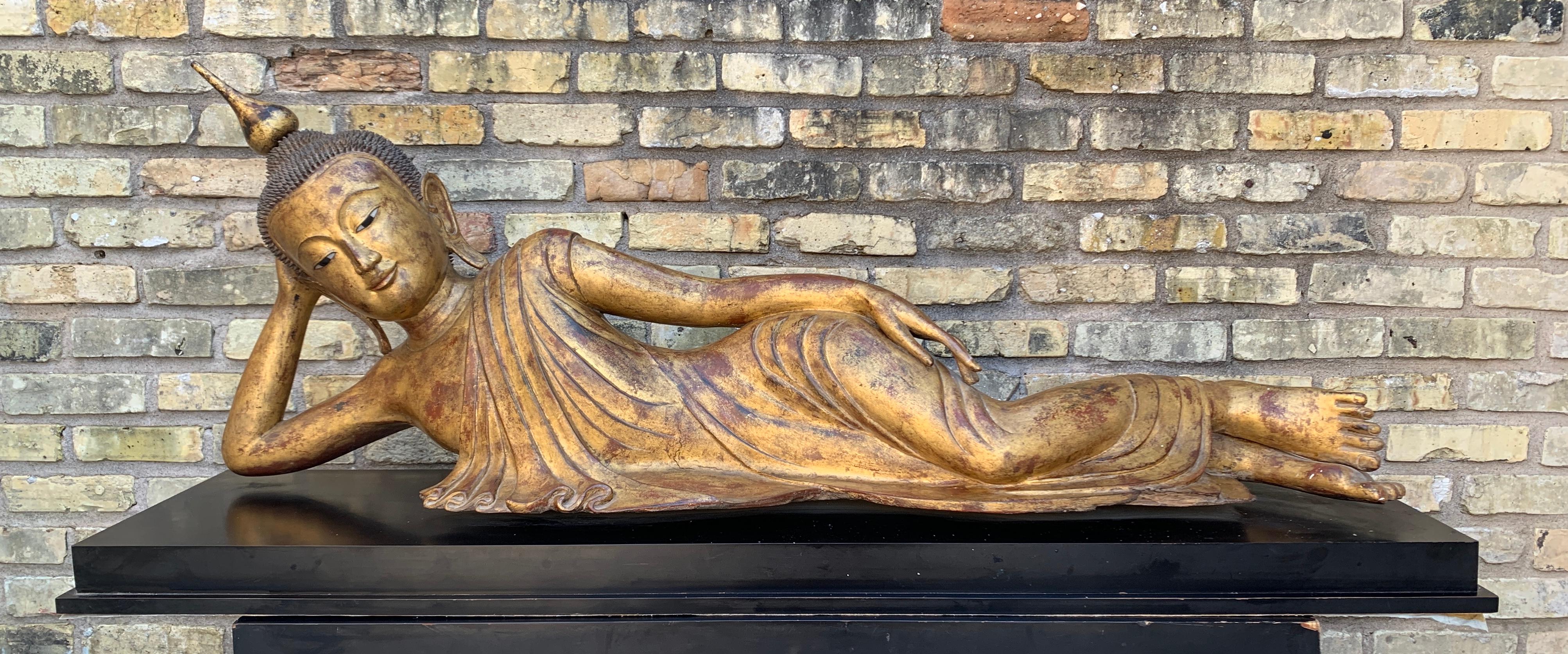 A large, near life-sized Burmese sculpture of the reclining Buddha, carved, lacquered and gilt teak wood, Shan States, Myanmar (Burma), early 20th century.

The Buddha is portrayed reclining languidly, almost seductively, on his side. His head