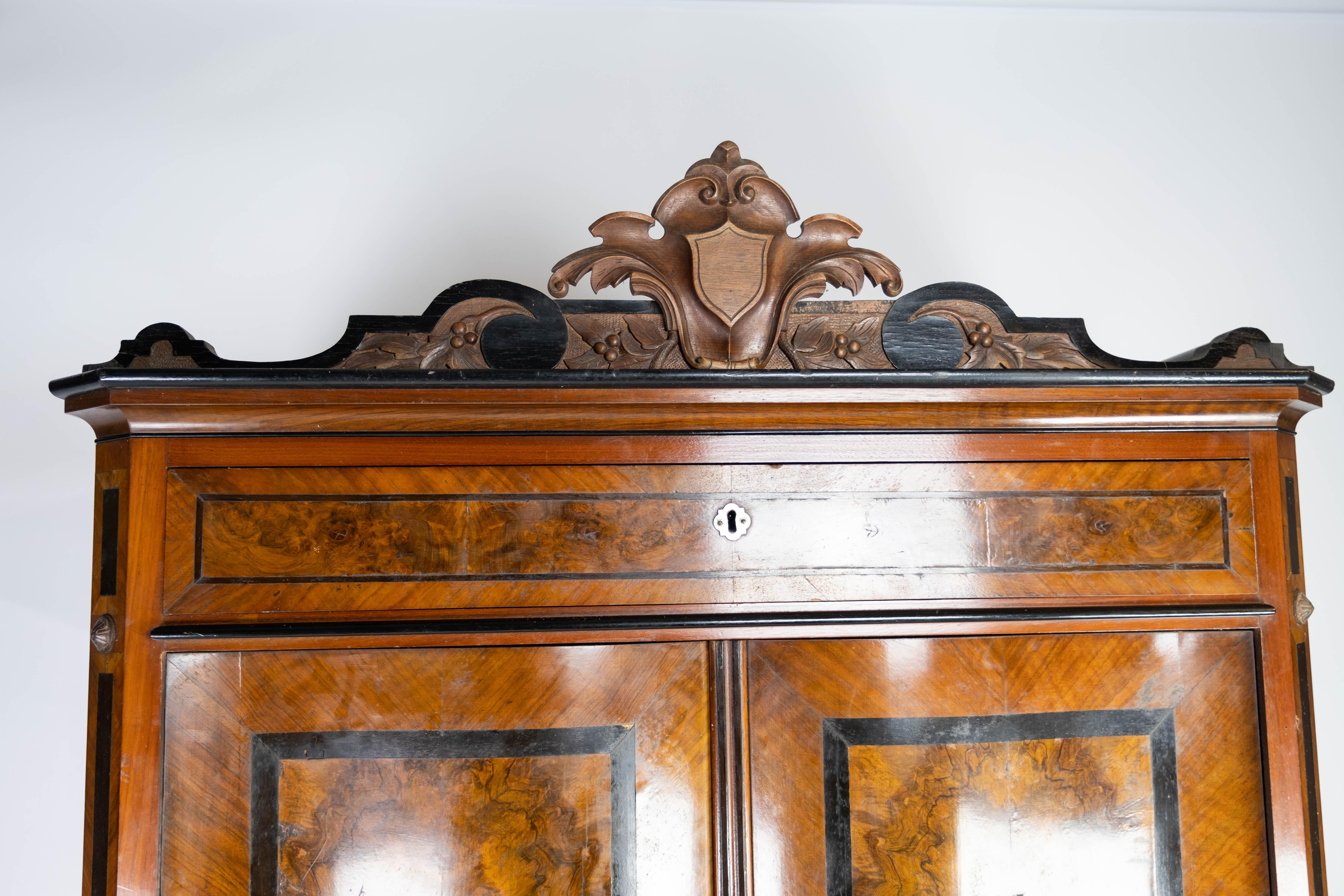 This secretary from the 1880s is a masterpiece of craftsmanship and elegance. Crafted from polished mahogany and walnut, it exudes timeless beauty and sophistication. The secretary's impressive wooden structure and fine details, such as the carvings