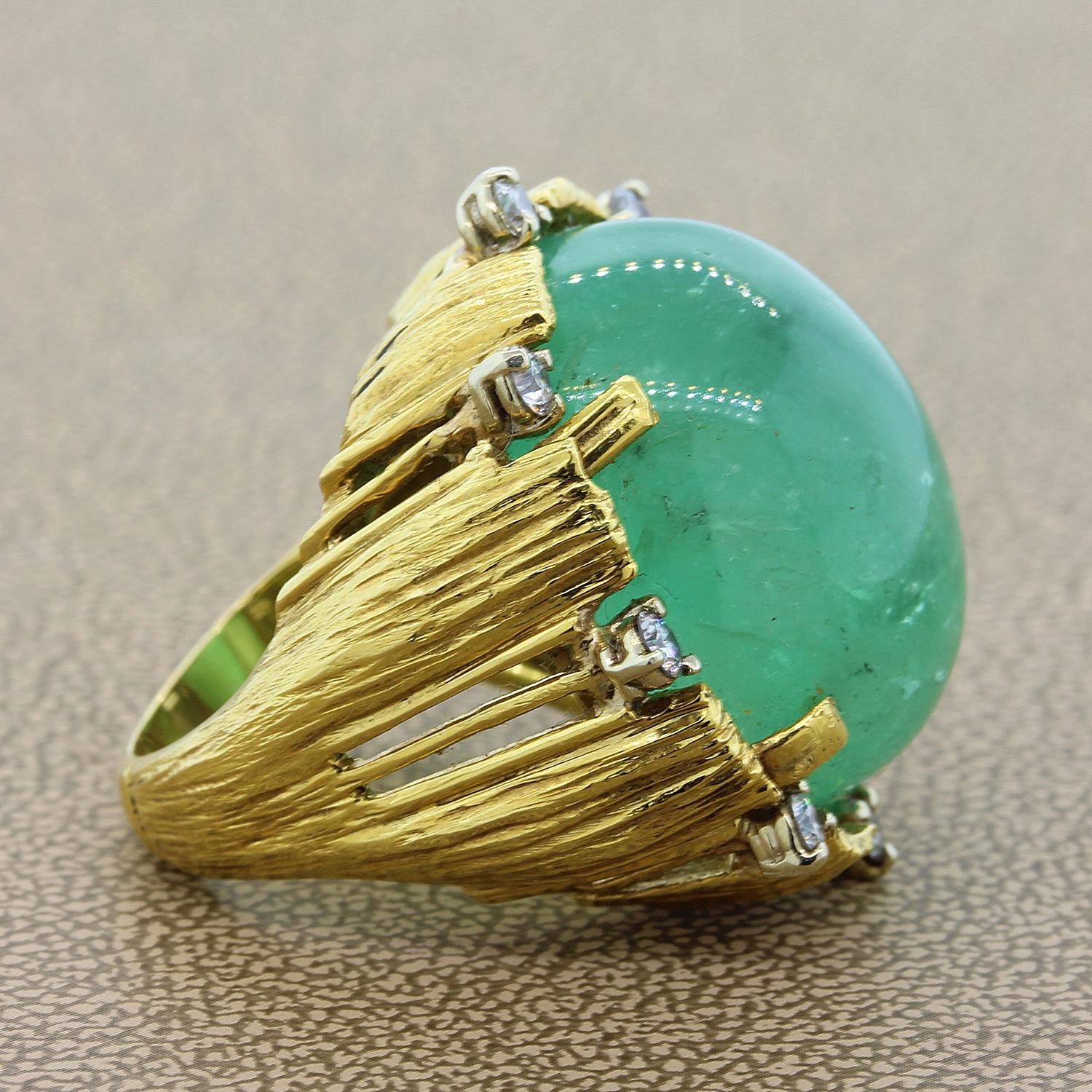 An estate cocktail ring featuring a large cabochon emerald weighting approximately 35 carats. The emerald is accented by 0.25 carats of round cut diamonds. The gems are set in a 18K yellow gold basket setting.

Size 5 ¼ 
