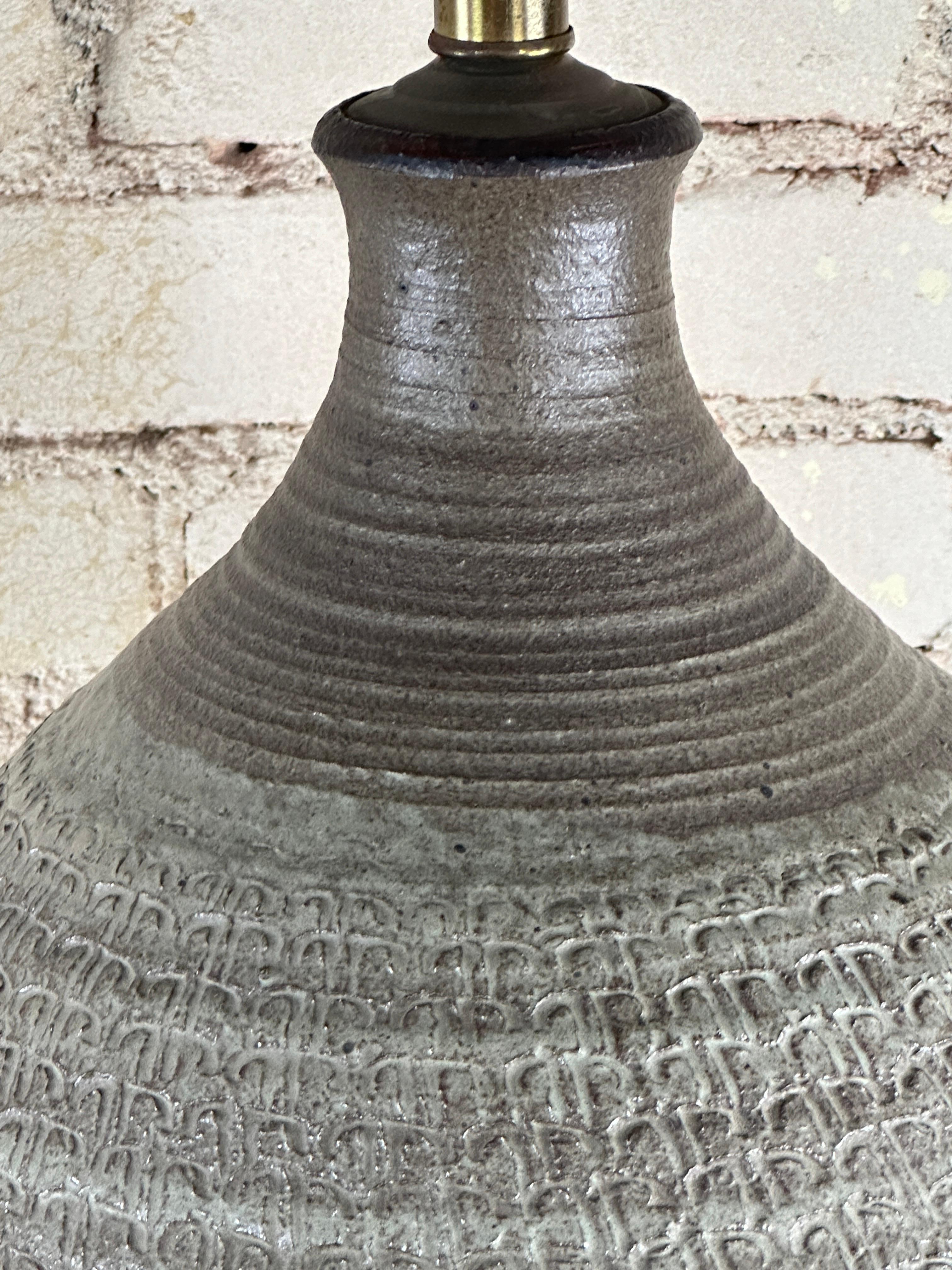 Ceramica lavorata a mano  lampada da tavolo con base in noce del ceramista Bob Kinzie per Affiliated Crafstmen, anni '60 circa. 
Bob Kinzie è uno dei lanciatori più incredibili.
All'inizio degli anni '60, insieme a due amici fondò un'azienda di