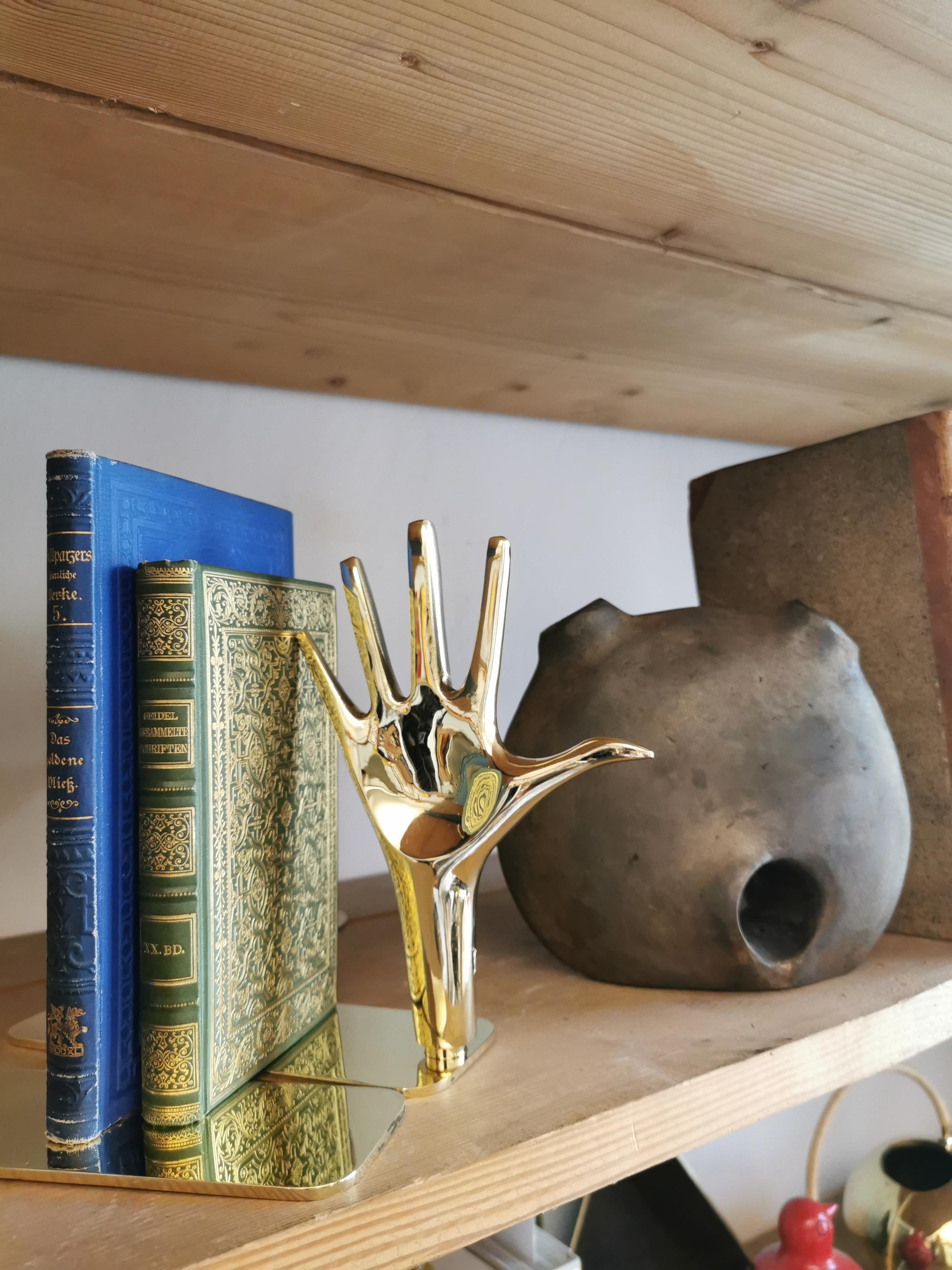 Pair of Large Carl Aubo¨ck Model #4219 'Hands' Brass Bookends. Designed in the 1950s, this incredibly refined and sculptural pair of bookends are executed in polished brass. Hand fully rotates and can be positioned palm outward or inward depending