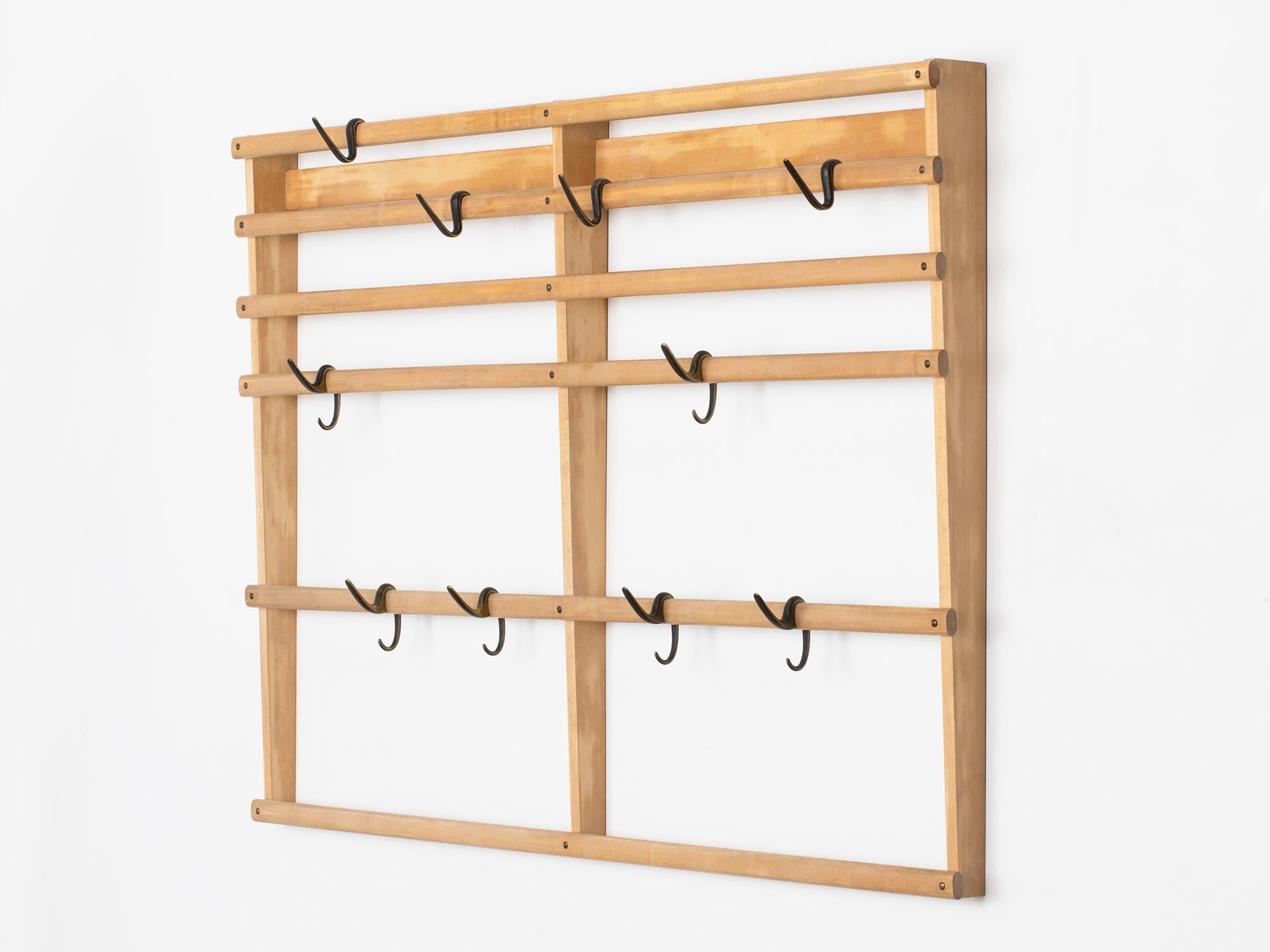 Large and rare Carl Auböck wall-mounted coat rack in natural maple wood with ten movable patinated brass hooks of two types. It is in excellent vintage condition. Made in Austria in the 1950s.
 