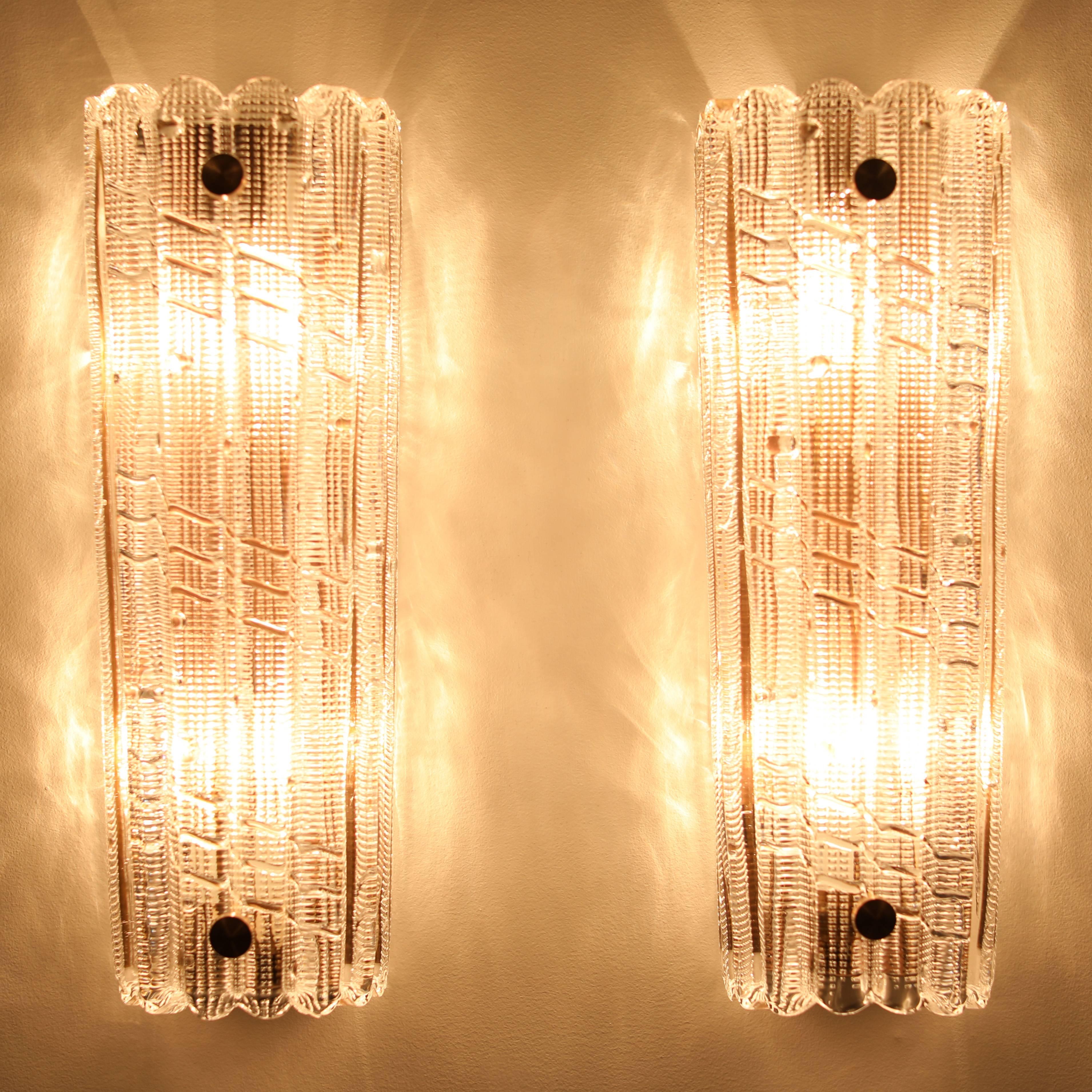 Large and stunning pair of thick mold-blown-glass sconces by Carl Fagerlund for Orrefors, Sweden, circa 1970s. The glass has cross-hatching and ribbing, producing a beautiful glow when lit. Each piece of glass tapers slightly from 5.25