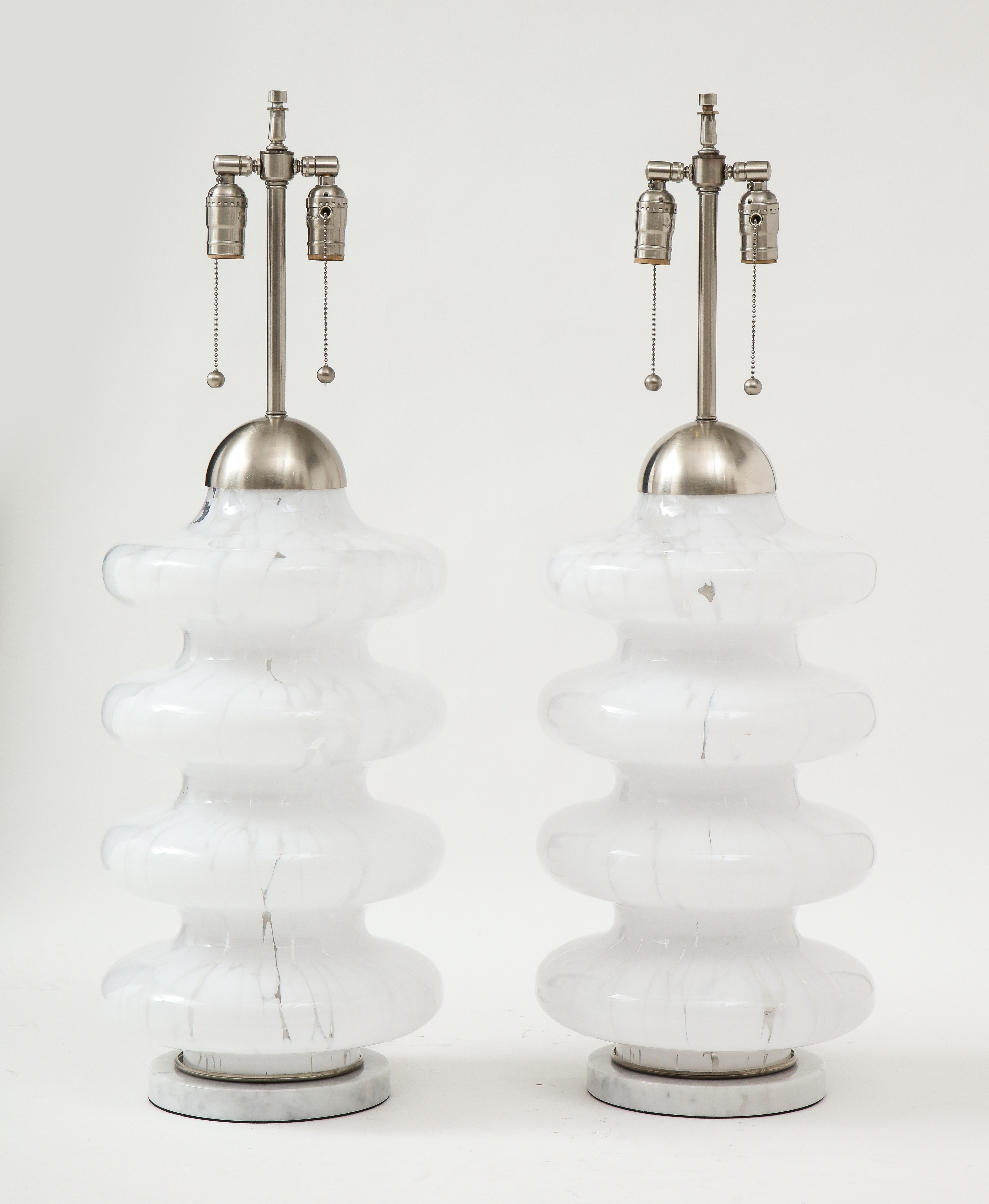 Pair of large scale Mazzega Murano glass lamps with mottled sinuous bodies sitting on white marble disc bases. Rewired for use in the USA using pull chain sockets. 75W max each socket.