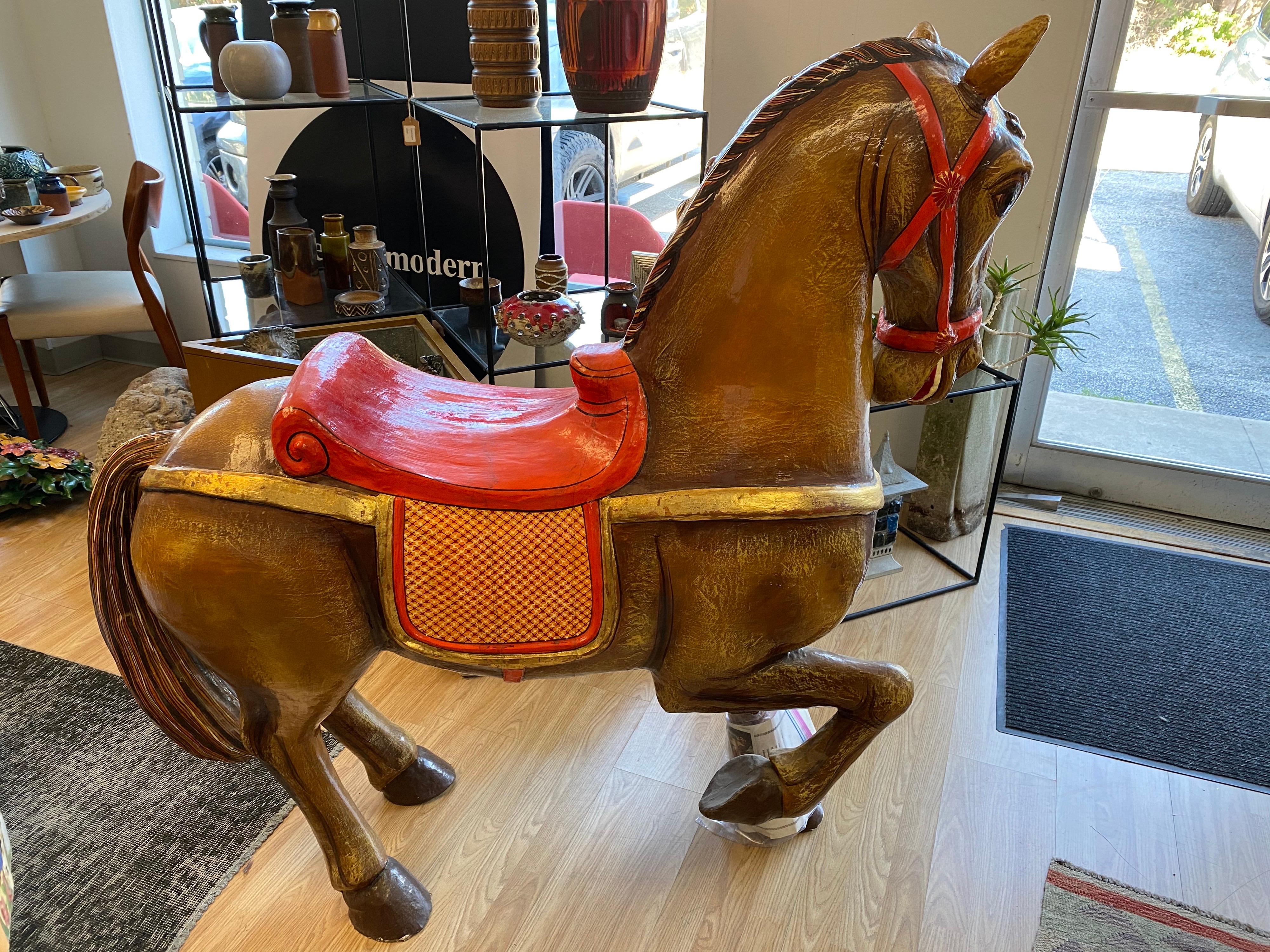 This beautiful carousel horse made of papier-mache designed by Mexican artist Sergio Bustamante comes with documentation papers and is signed and numbered. This vintage piece is in good overall condition; wear is mostly around the hooves. 