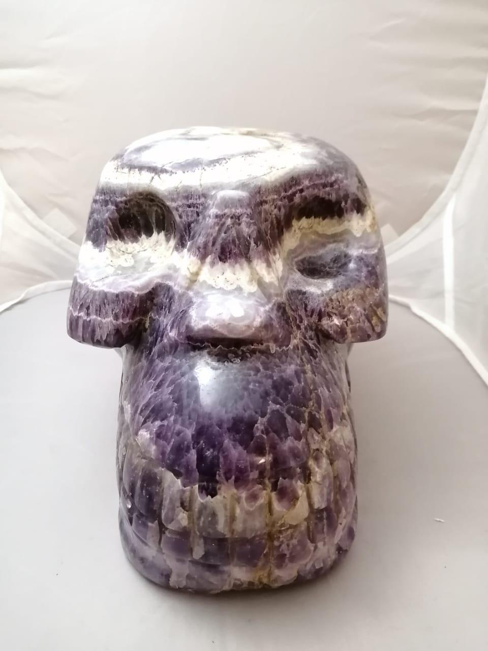 A large and heavy carved amethyst quartz sculpture in the shape of a skull.