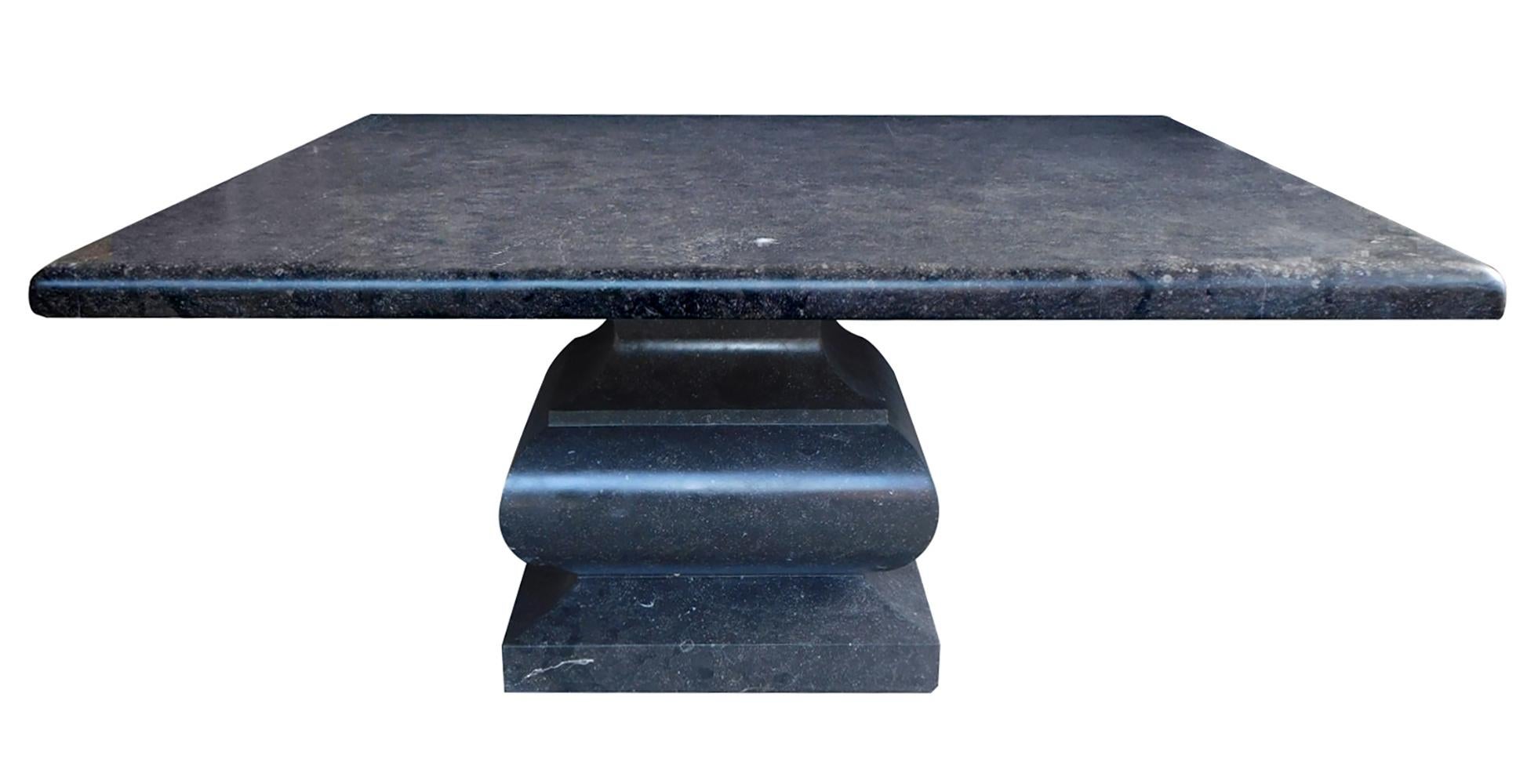 Made from Belgian bluestone with a honed finish and embedded with fossils, the table is comprised of a thick square top with bullnose edge and baluster-form support. New with only minimal wear expected, table is ideal for exterior design projects.