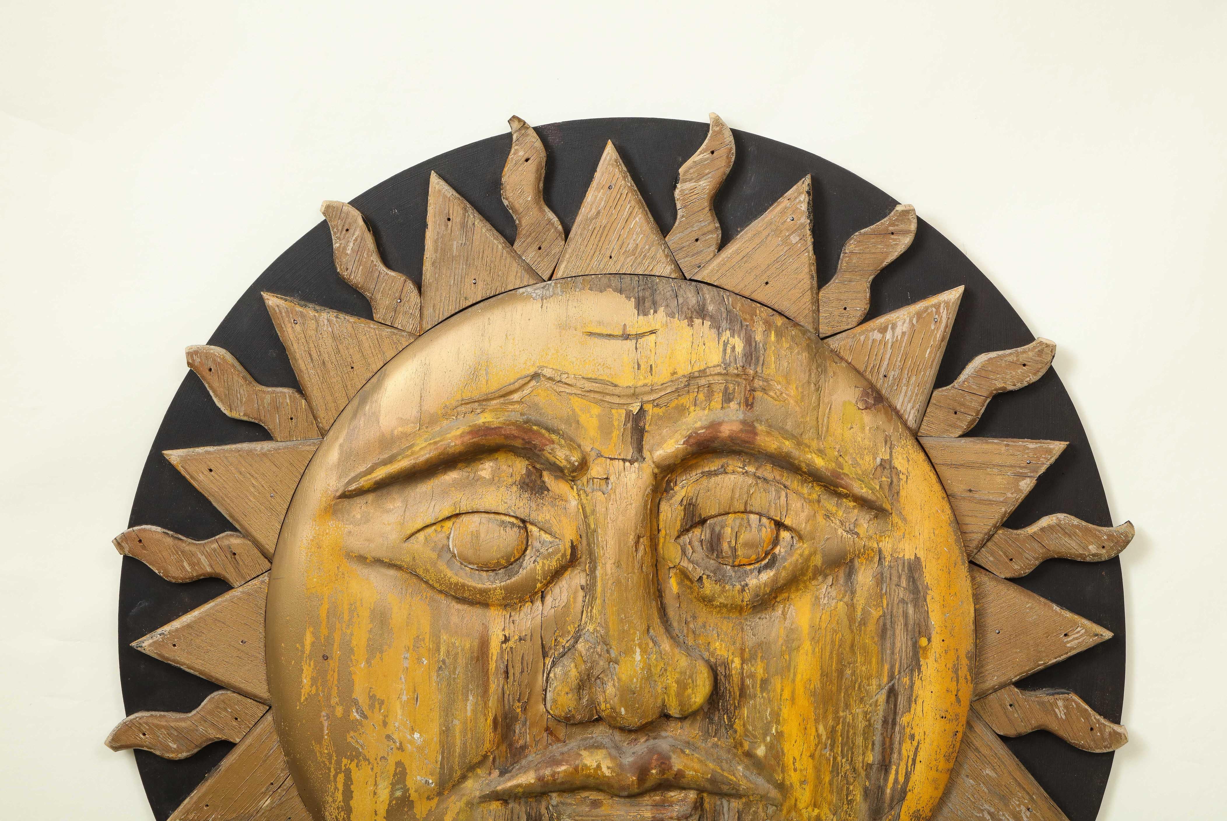 Bois Grand soleil sculpté et peint en noir et or en vente