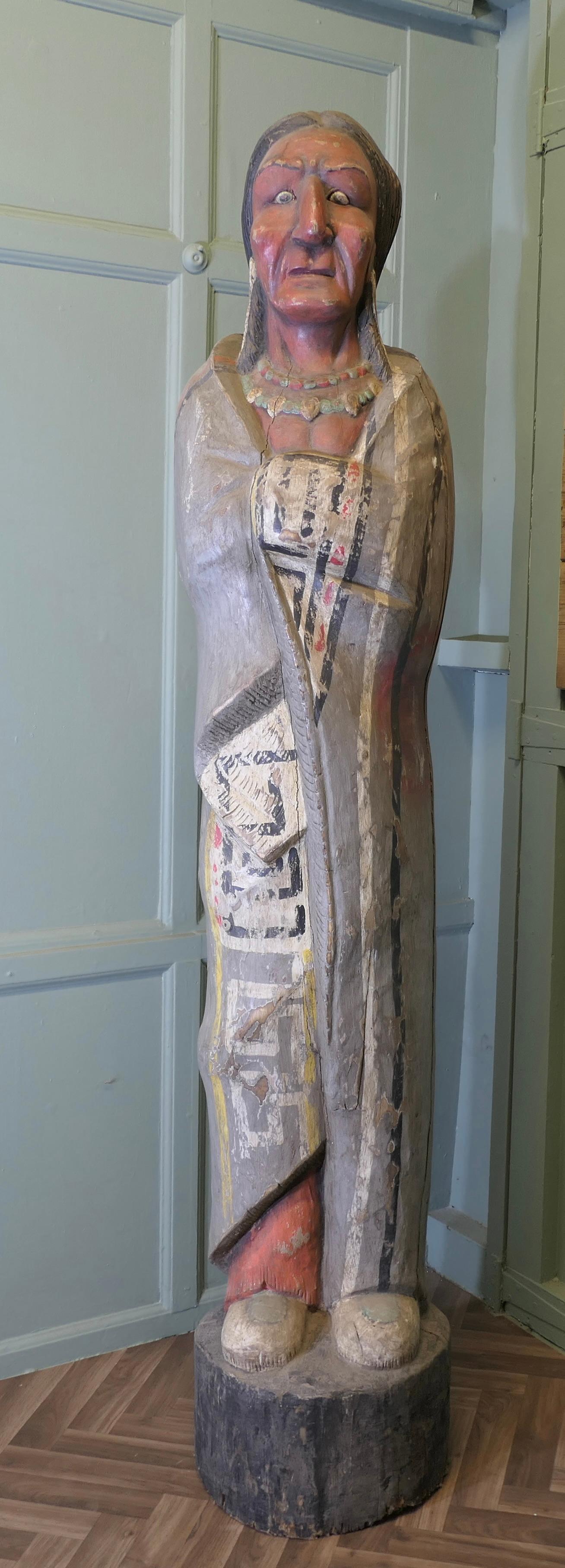 Grand Indien sculpté pour magasin de cigares, enseigne de magasin

Il s'agit d'un Indien d'Amérique de taille normale, sculpté dans un seul morceau de bois (un tronc d'arbre, peut-être du pin).
La statue devait se trouver à l'extérieur d'un magasin