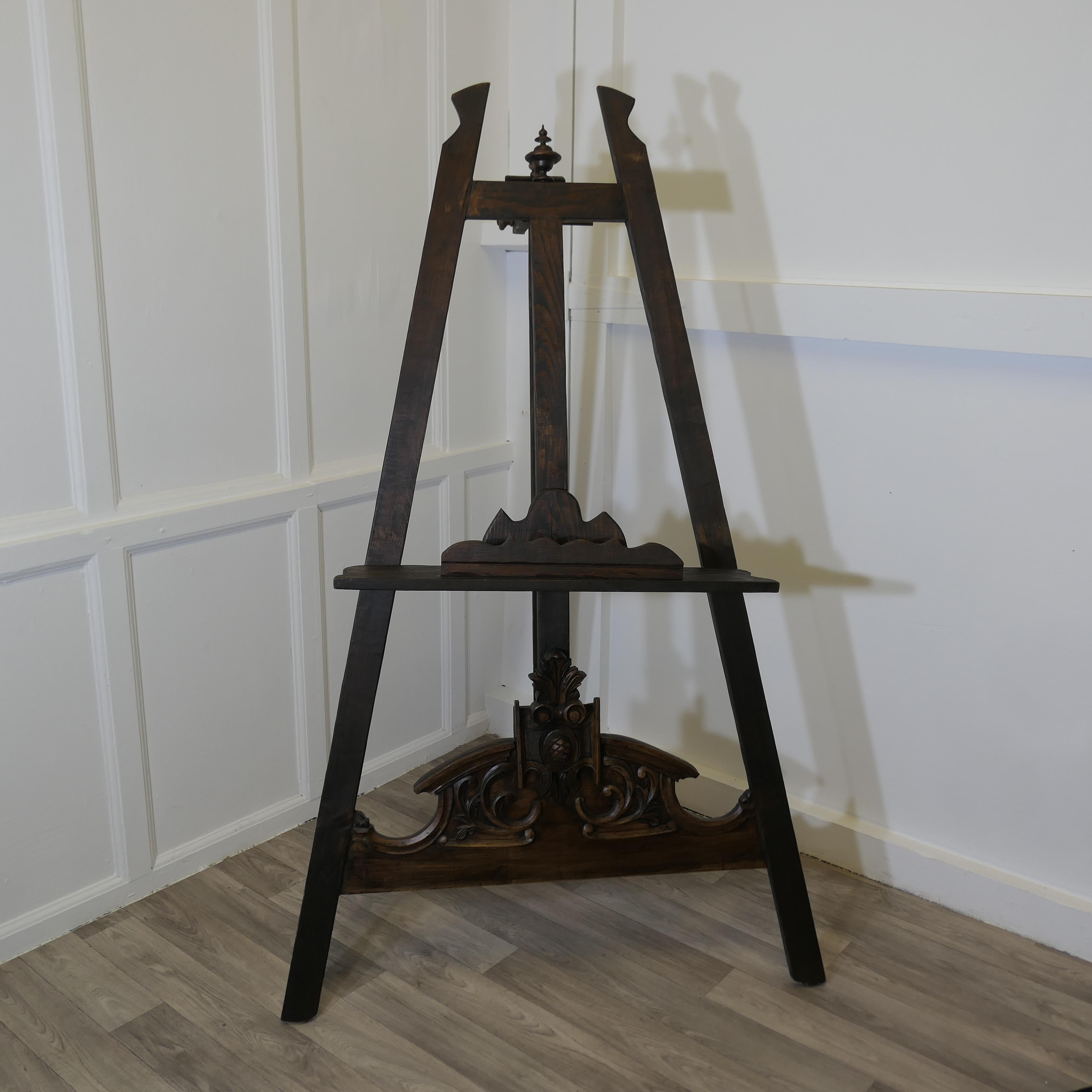Large Carved Display Easel

This is a very attractive piece it has a slightly gothic look due to the carving The frame has a wide picture rest and it folds flat for storage
The easel is in good antique condition with a pleasant patina it is 59”