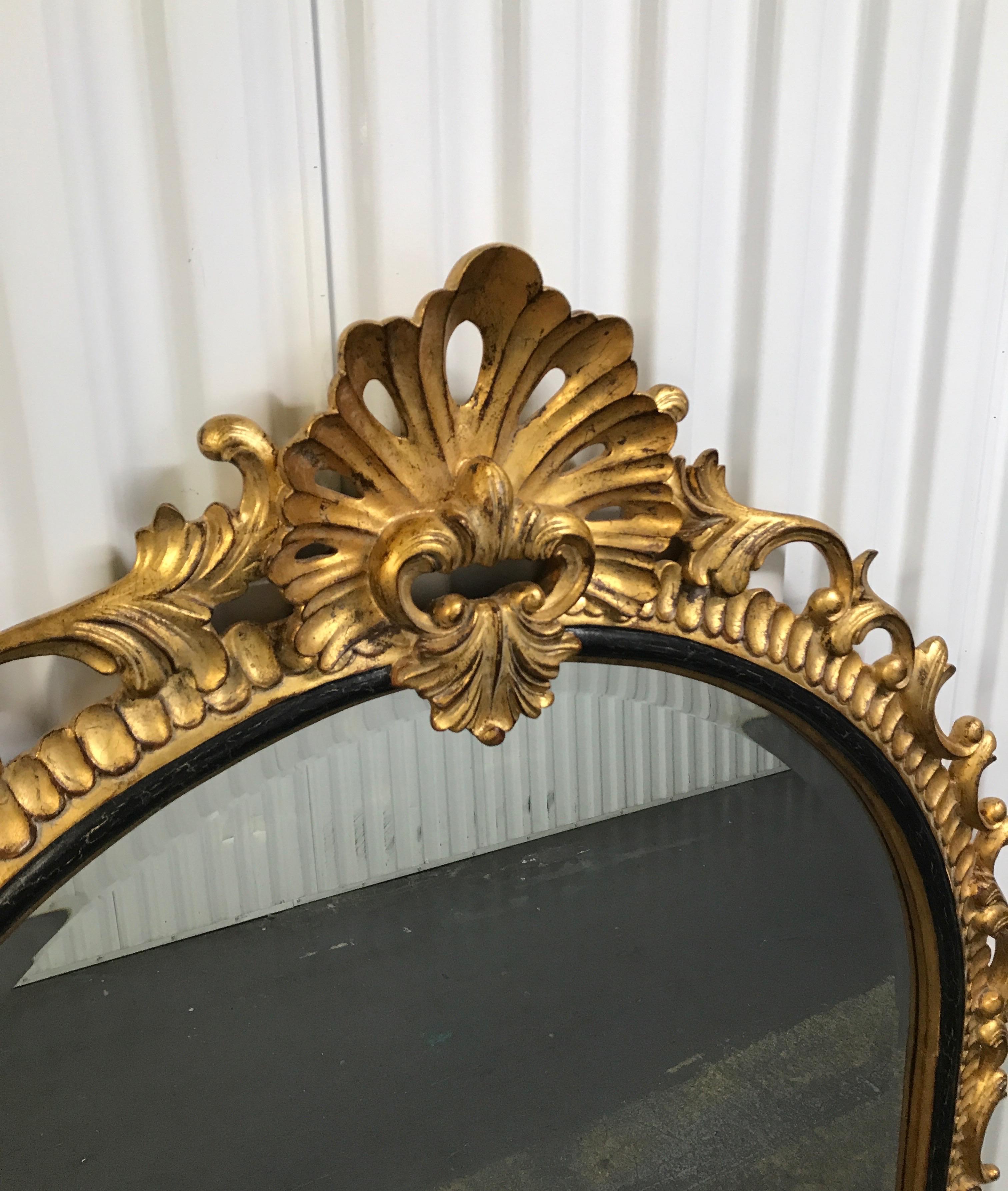 Hand carved and gilded arched shaped shell mirror by Harrison & Gil.