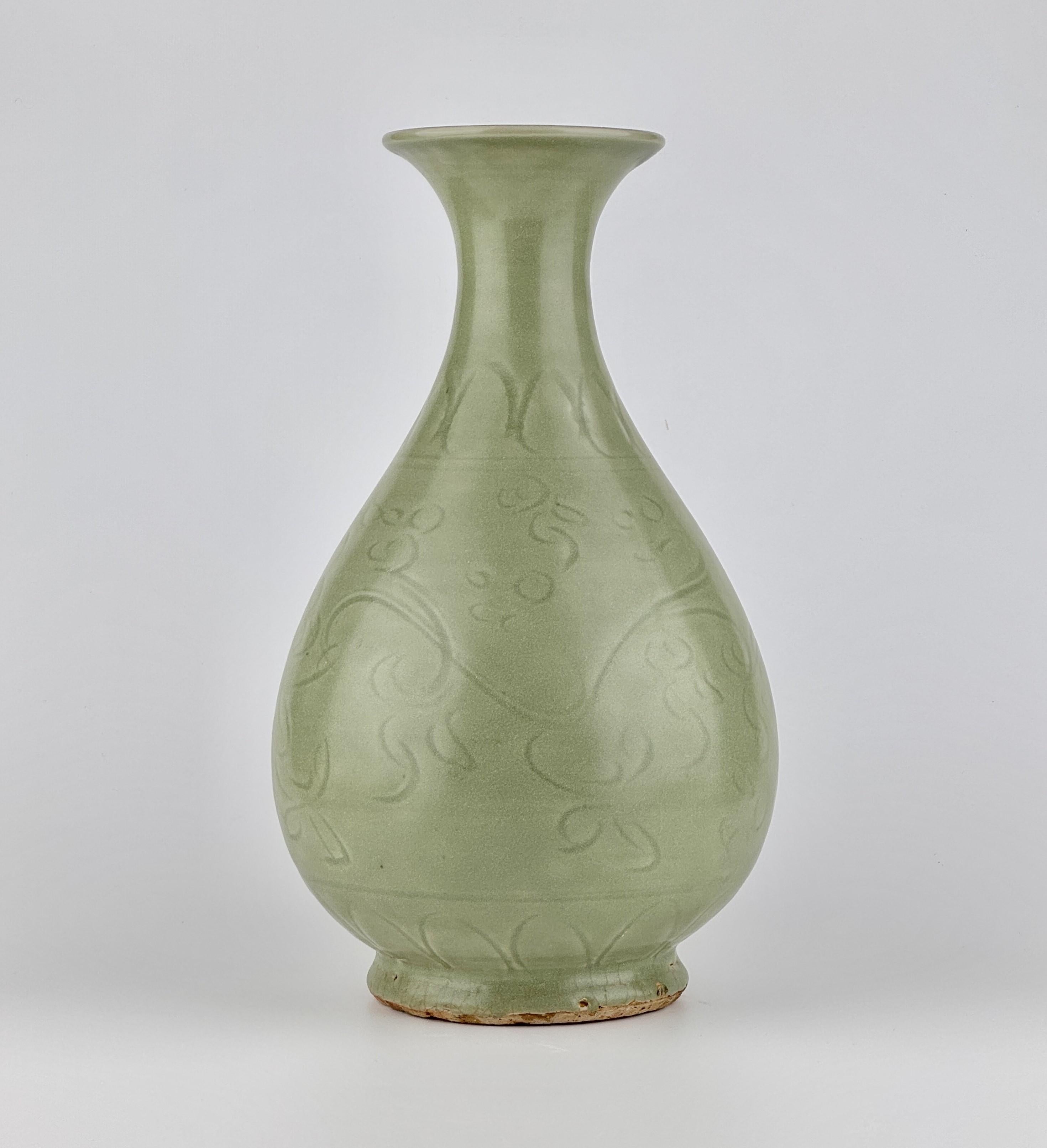 The bulbous body is adorned with elegantly carved floral motifs, with intertwining vines and flowers forming a natural, flowing pattern. The base is left unglazed. Base surface cracking is occasionally observed, primarily in ceramics excavated from