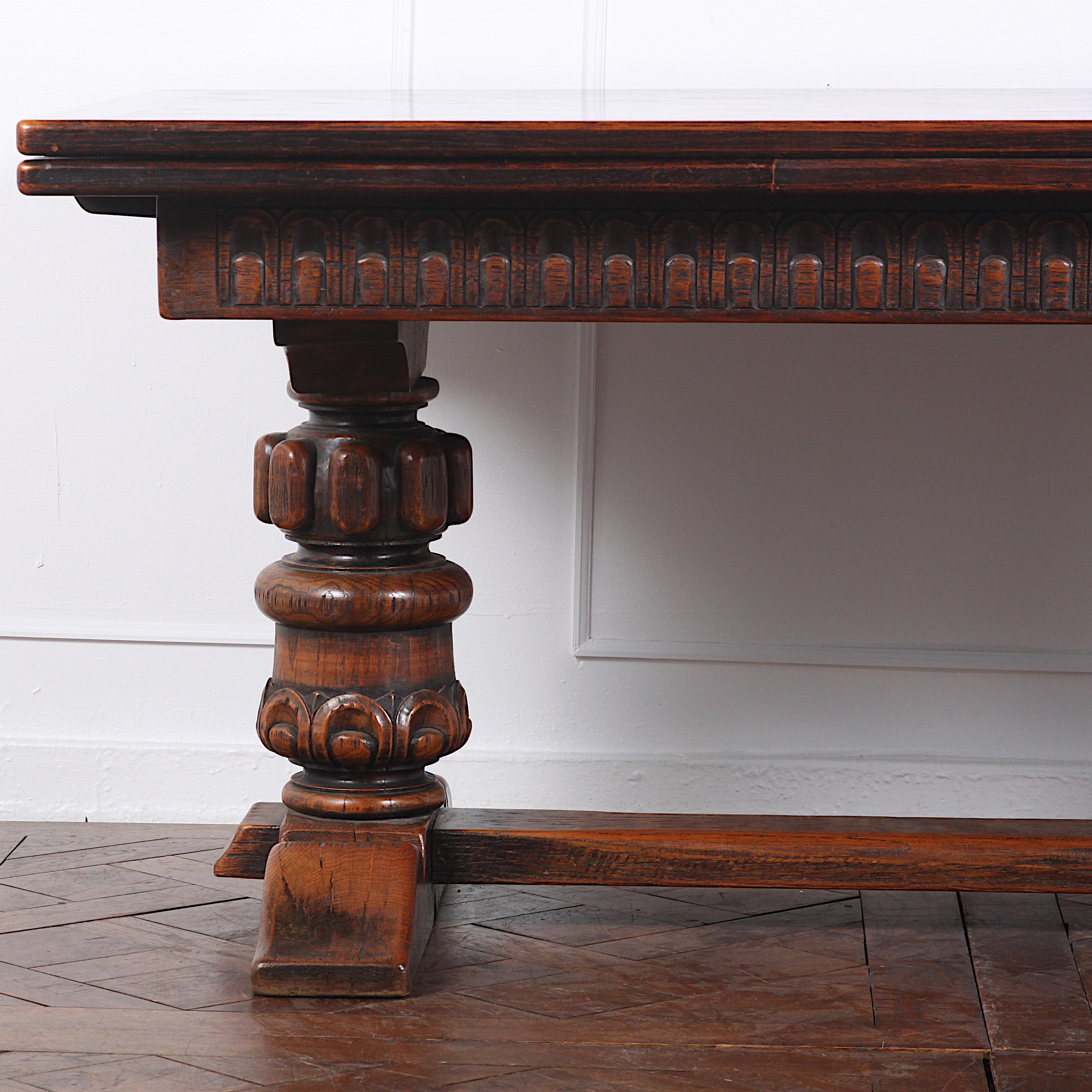 Large carved oak Flemish draw-leaf table having two large turned and carved pedestal legs with shaped feet united by a solid oak stretcher. Parquet top with matching pull-out leaves. A handsome and sturdy table suitable for everyday use. The inset