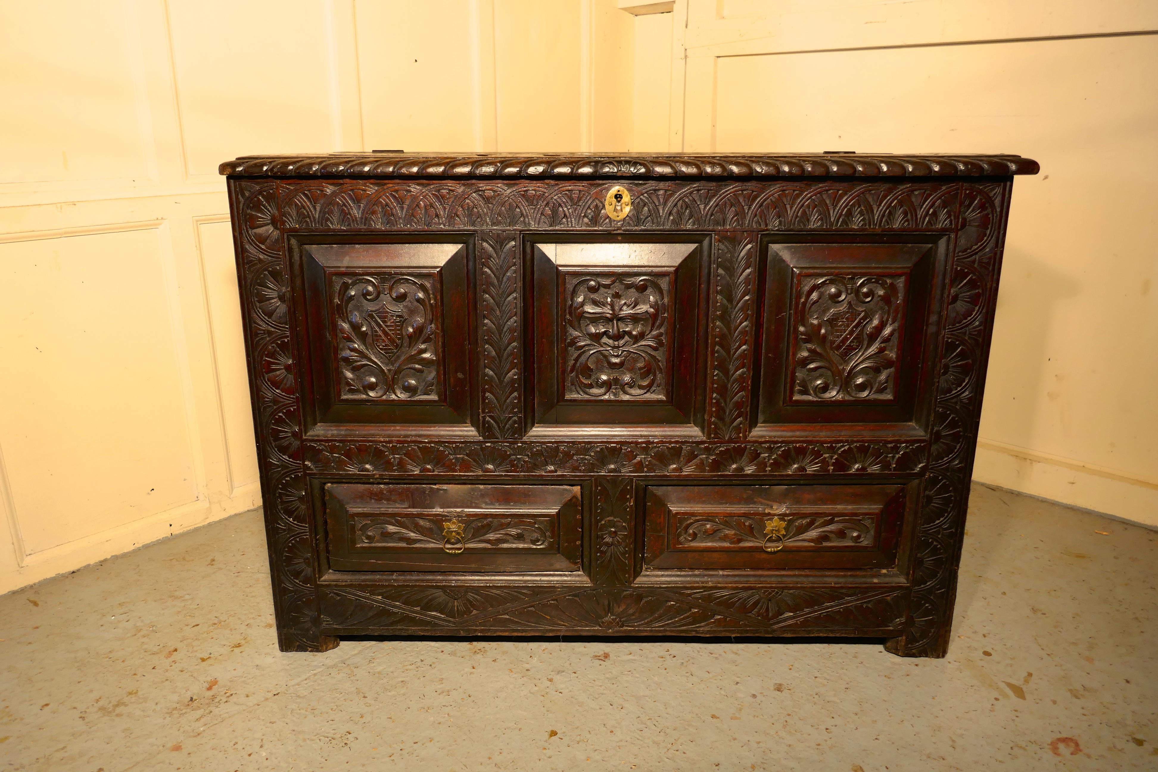 Large Carved Oak Mule Chest, Green Man Marriage Chest

This is a profusely carved Marriage chest, the coffer has many detailed carved panels. On the front we have 2 family crests on either side of the Green man’s face, and on the top we have another