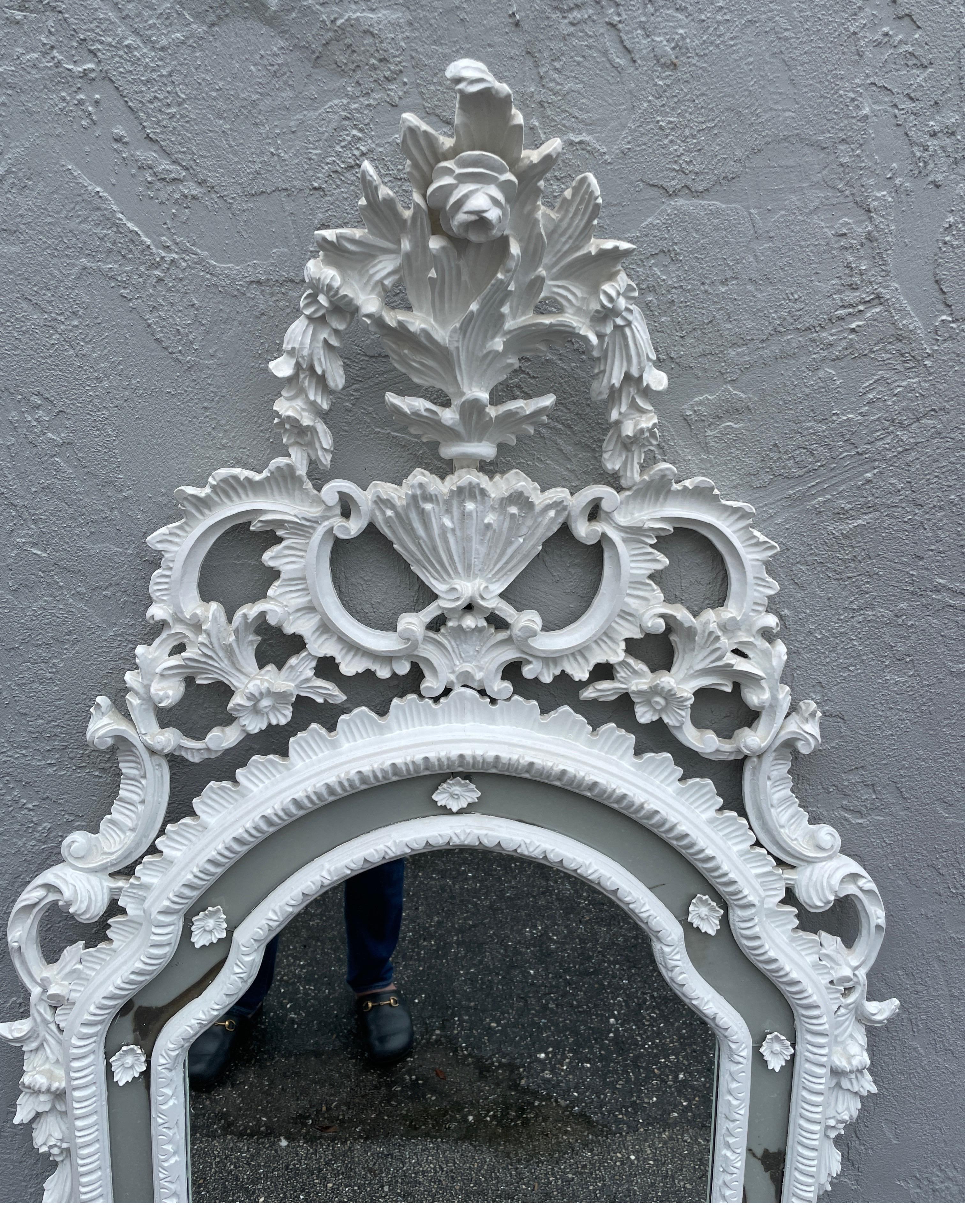 Large carved and white painted Rococo Italian wall mirror. Center mirror plate surrounded by mirrored border with white carved wood appliques.