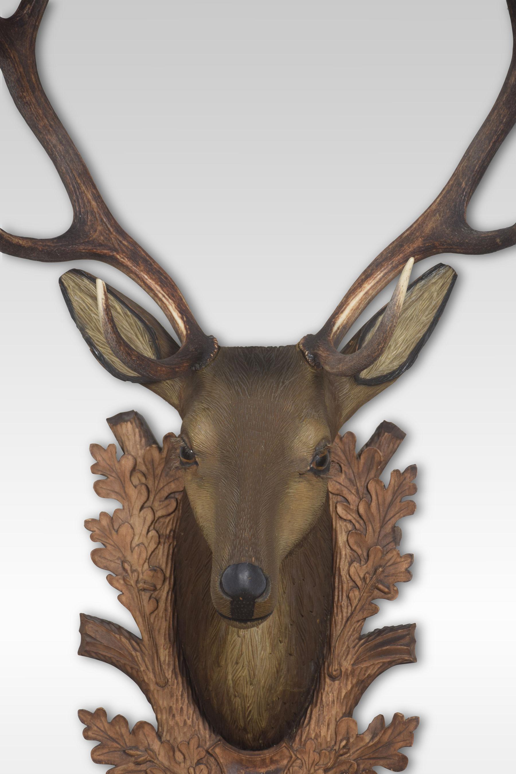 Large carved wood and polychrome decorated stags head, carved with glass eyes and taxidermy antlers. Mounted on carved back plate.
Dimensions:
Height 48.5 inches
Width 24.5 inches
Depth 16 inches.