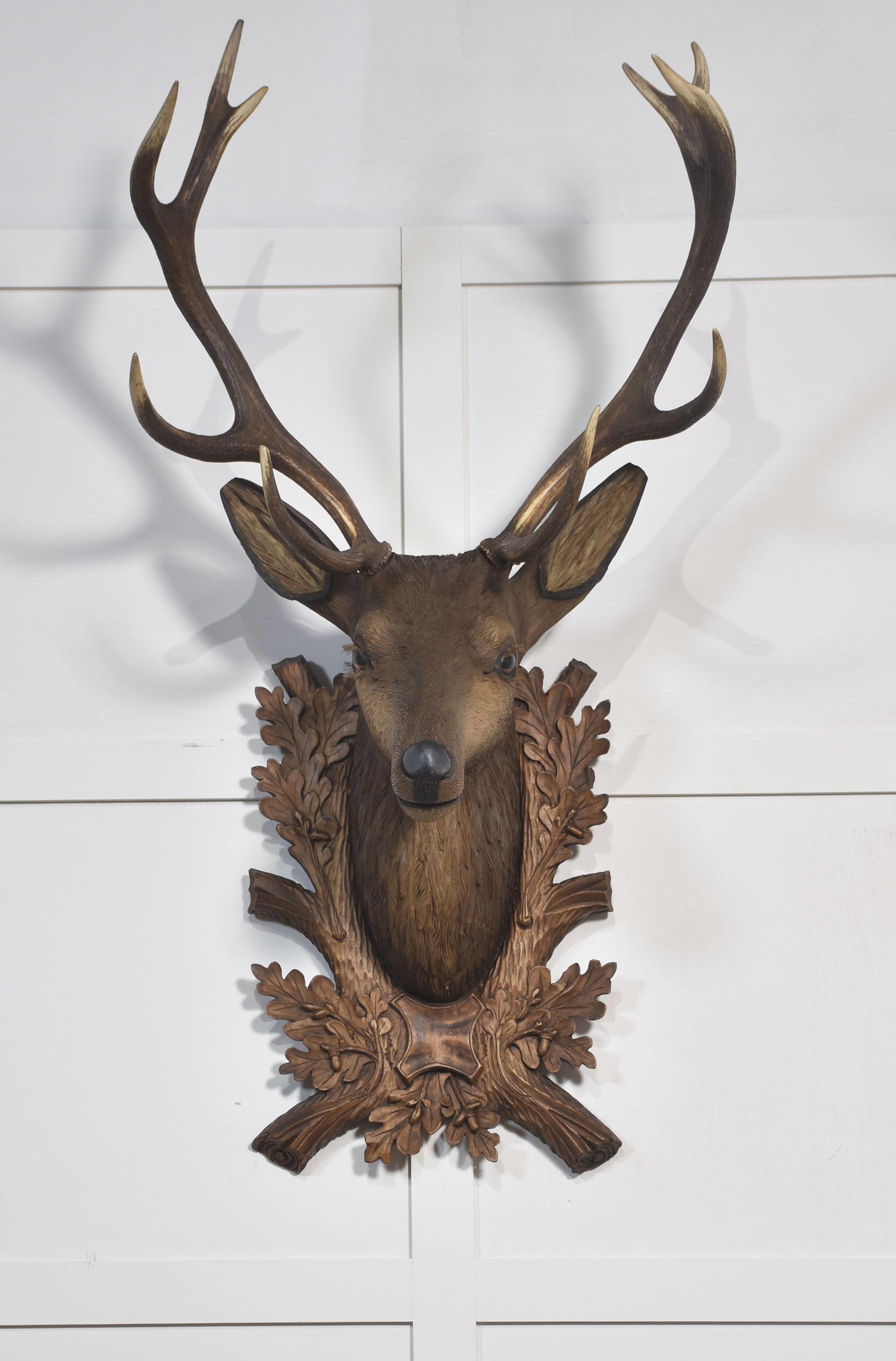 Großer geschnitzter und mehrfarbig verzierter Hirschkopf, mit Glasaugen und taxidermischem Geweih. Montiert auf geschnitzter Rückenplatte.
Abmessungen
Höhe 48,5 Zoll
Breite 24,5 Zoll
Tiefe 16 Zoll