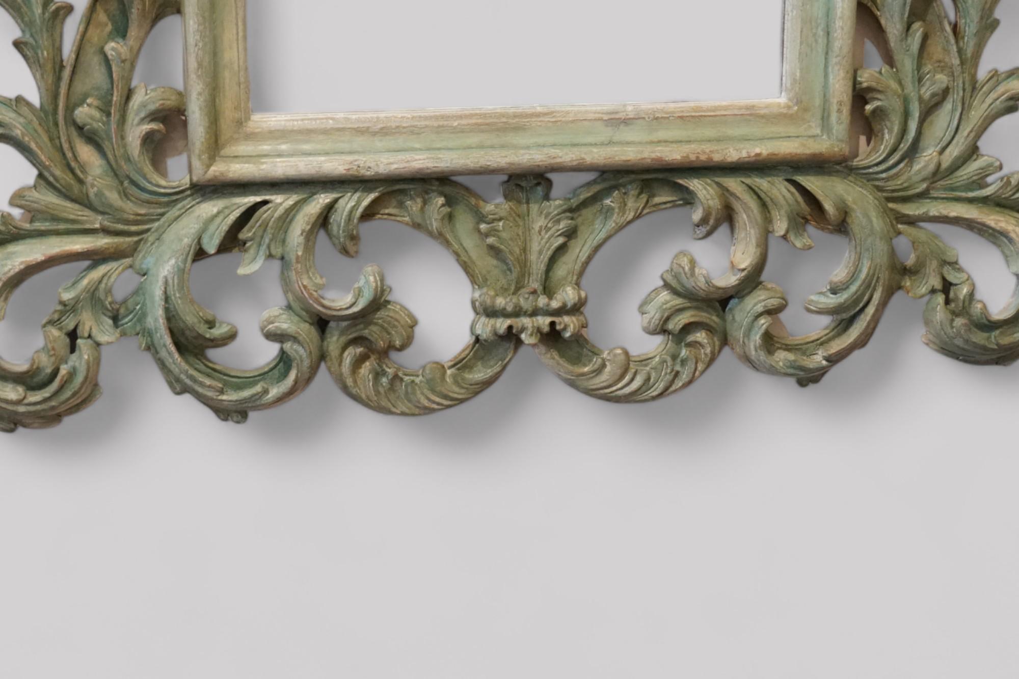 Impressive carved teak Florentine mirror 
This impressive carved teak mirror is of an important size.
It has a deeply carved frame is in the Florentine design with free-flowing carving of leaves, and painted decoration in eau de nil colour. The